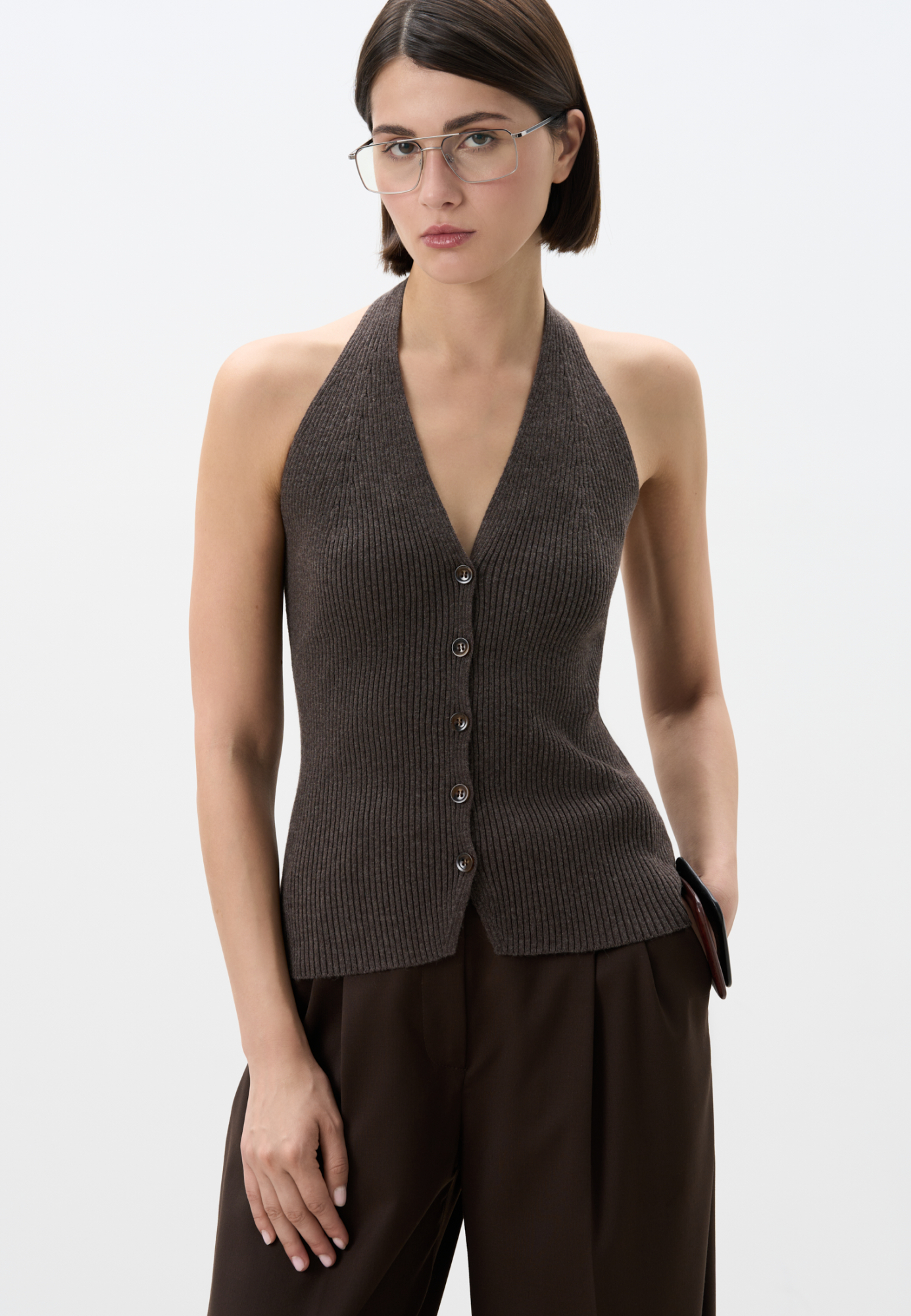 Трикотажный жилет в рубчик из шерсти и кашемира. Модель по фигуре с V-образным вырезом и американской проймой. Застежка на пуговицы. 