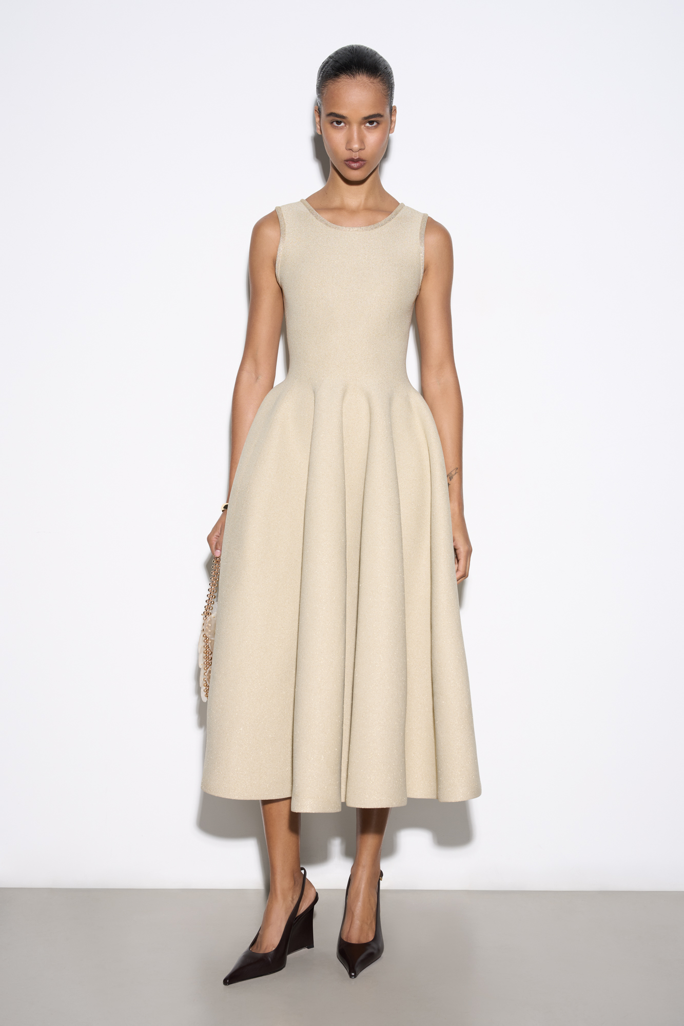 Трикотажное платье длины миди с люрексом. Модель по фигуре с юбкой, расклешенной от талии, без рукавов, на широких бретельках.