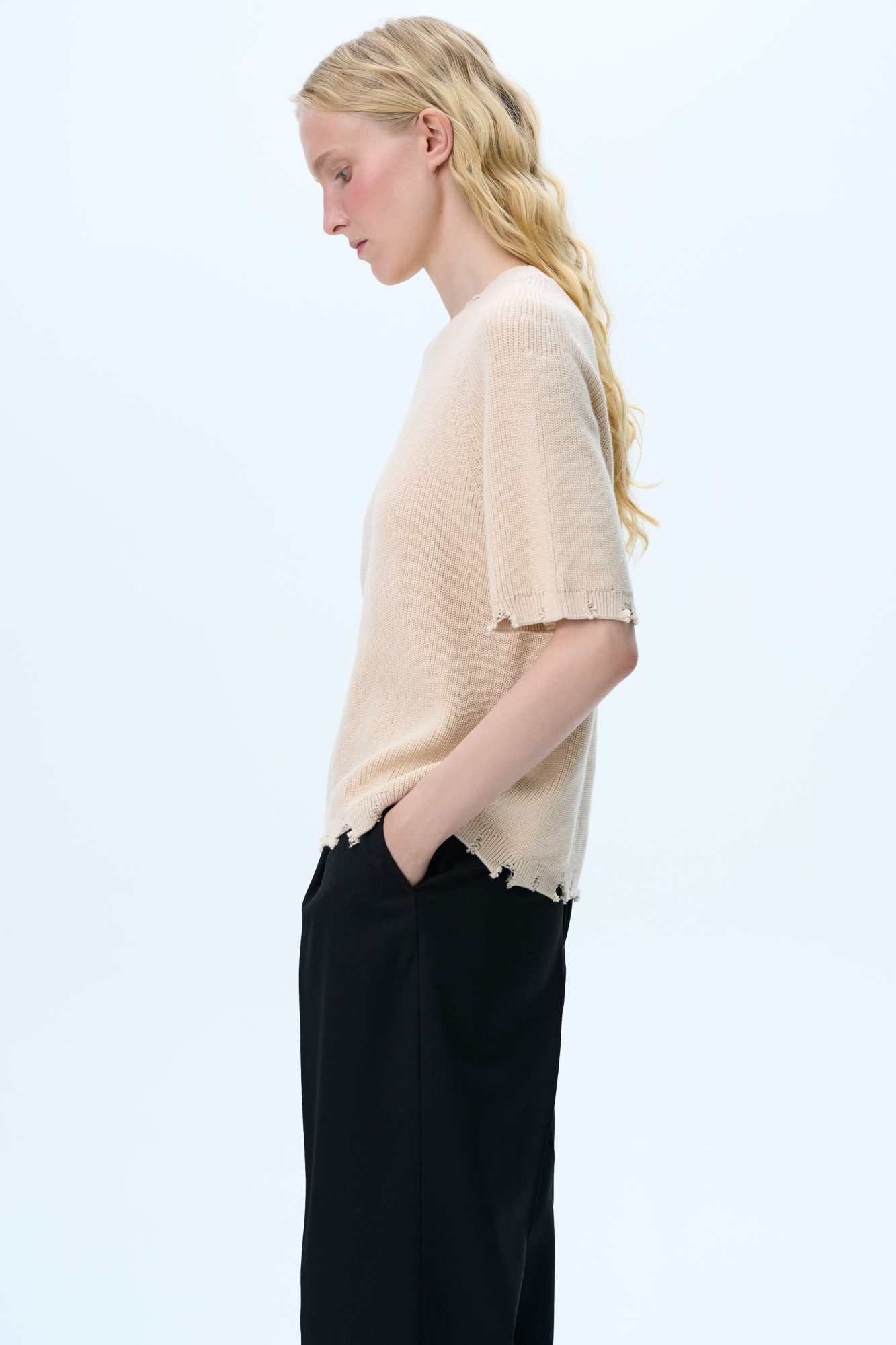 Трикотажная футболка из 100% хлопка. Модель свободного силуэта, со спущенной линией плеча, коротким рукавом и брендированным ярлыком на рукаве. Имитация необработанного края по низу изделия, на манжетах и воротнике. 