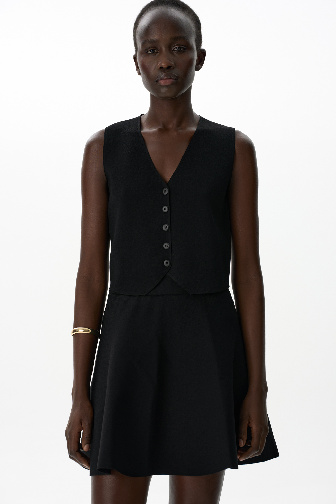 Трикотажный жилет из вискозы. Модель прямого кроя с V-образным вырезом и застежкой на пуговицы. 