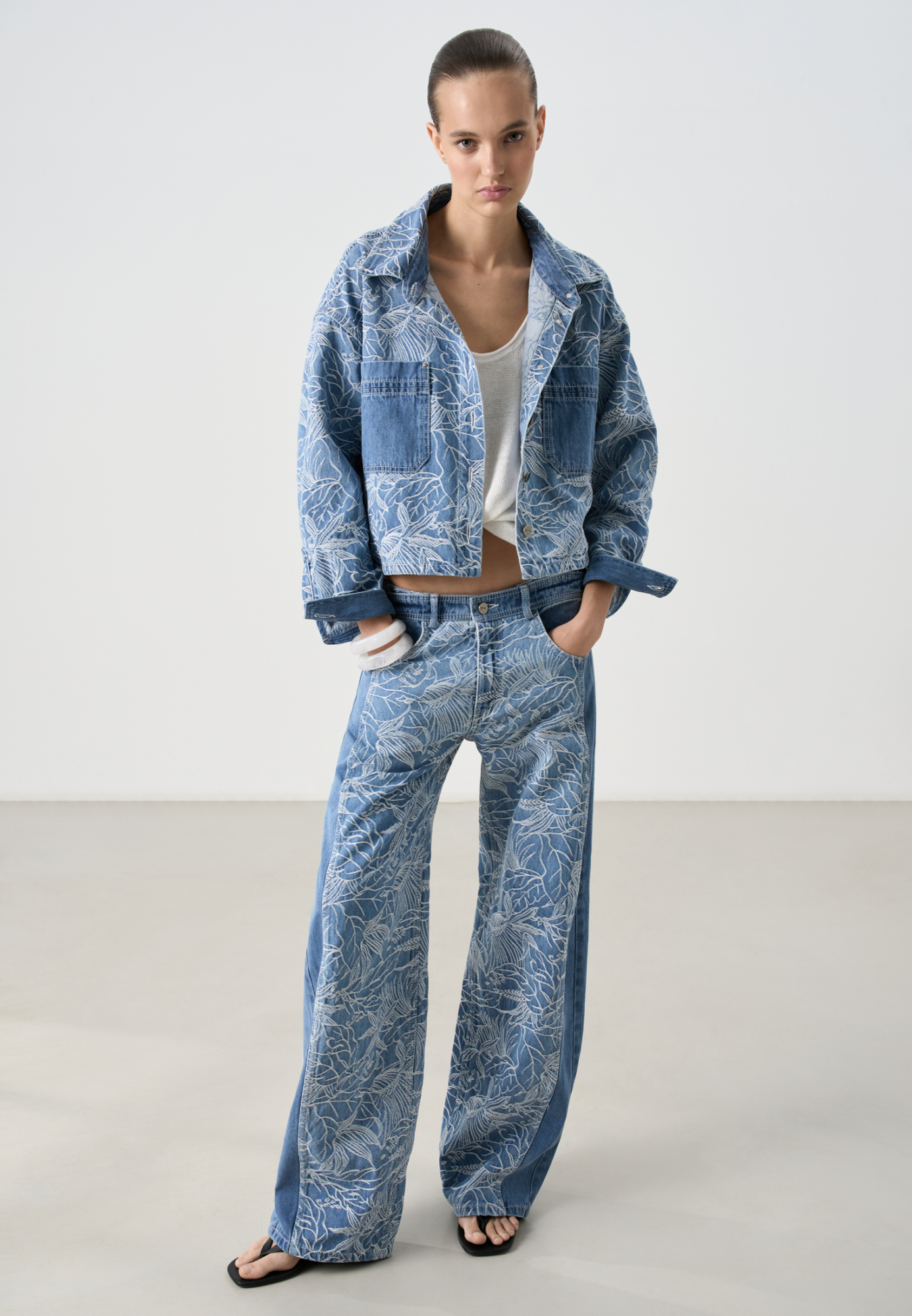 Принтованные джинсы из 100% хлопка. Модель прямого кроя, с вертикальными вытачками и широкими лампасами. Шлевки на поясе для ремня, застежка на молнию и пуговицу. 4 кармана. 