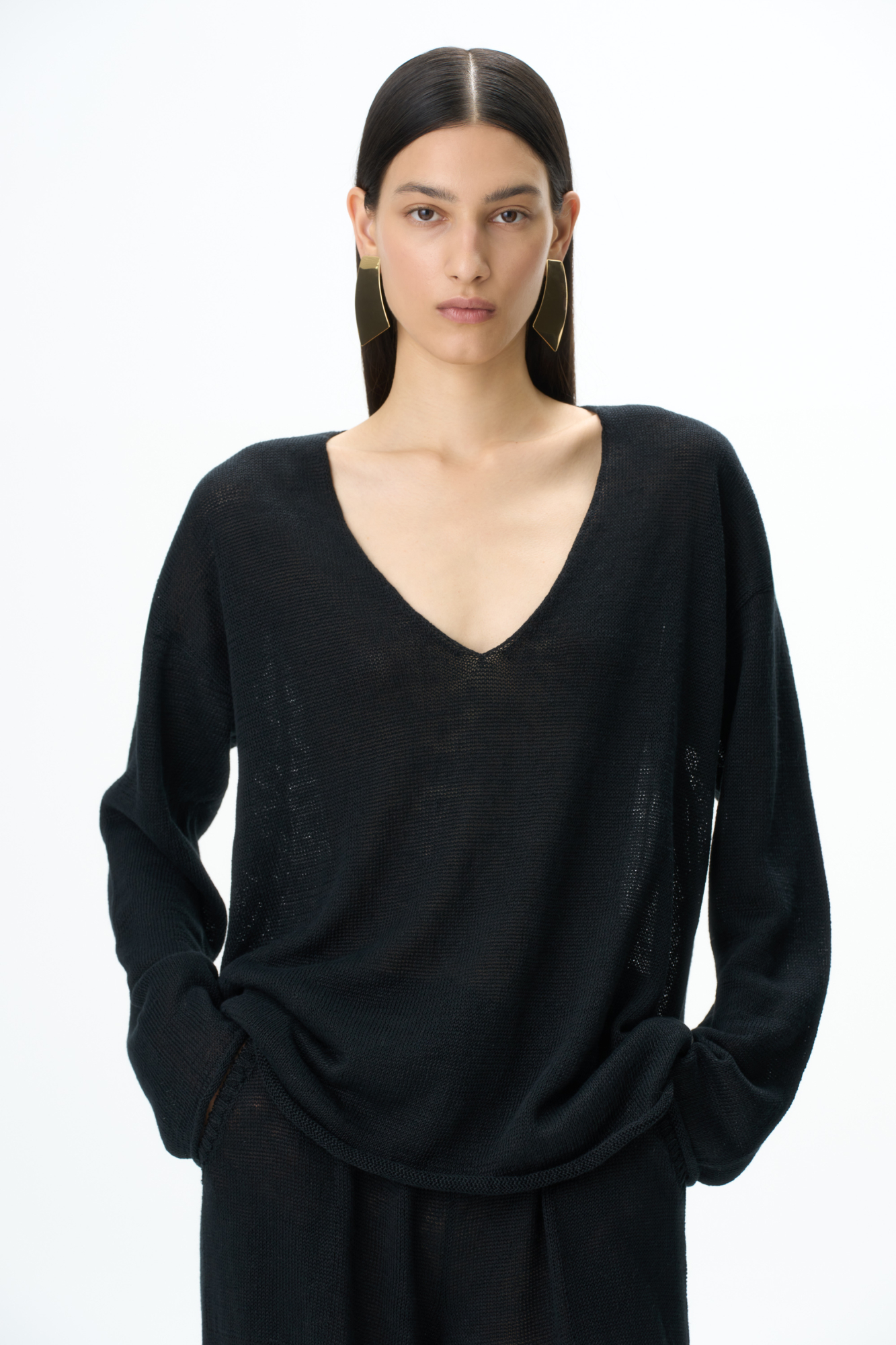 Трикотажный джемпер из 100% льна. Модель свободного силуэта с длинным рукавом и с V-образным вырезом горловины. Изделие декорировано брендированным ярлыком сбоку и валиками по низу.