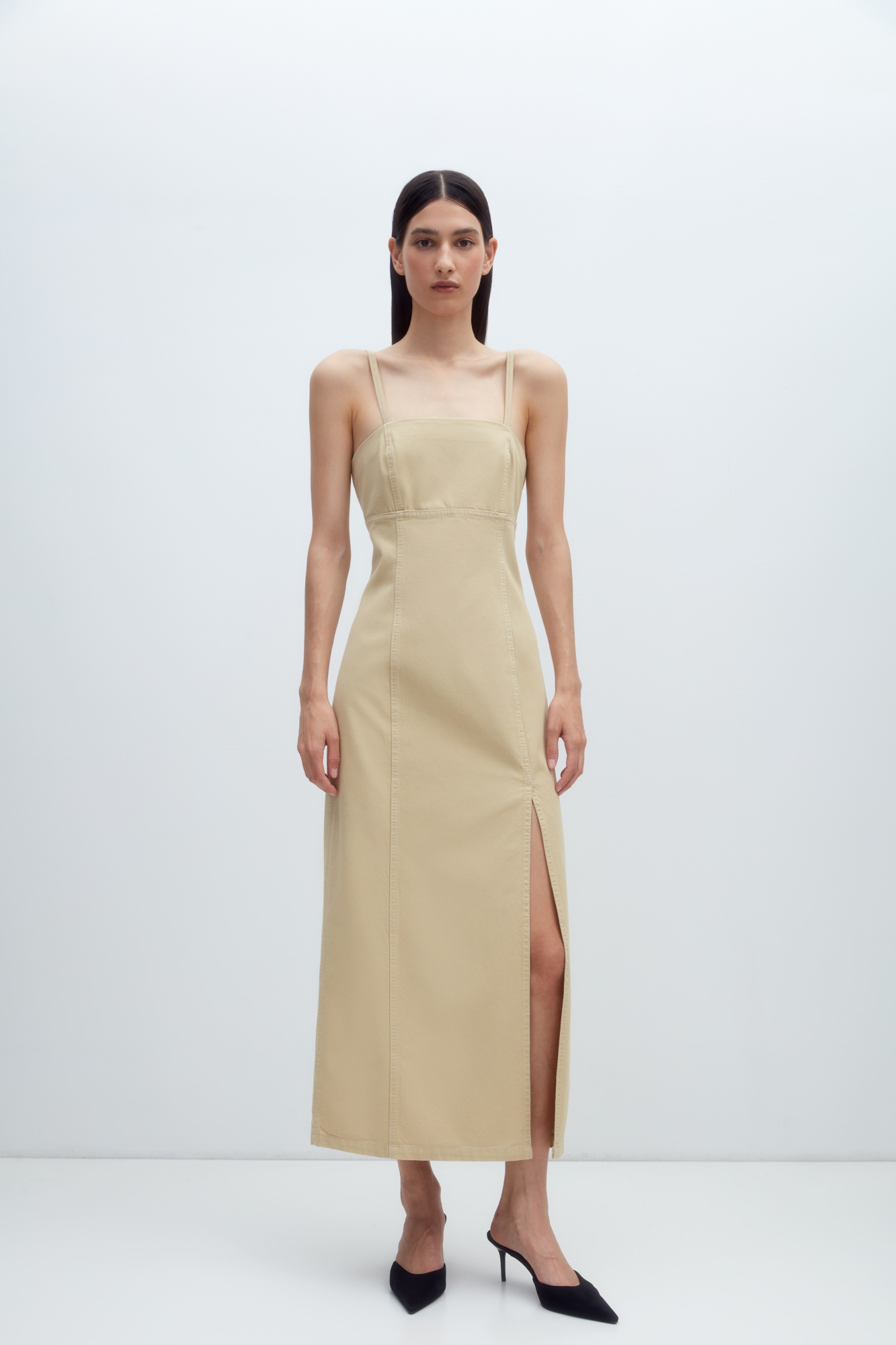 Джинсовый сарафан из 100% хлопка с разрезом от бедра. Модель приталенного силуэта, на тонких регулируемых бретелях. С застежкой на молнию сзади. 