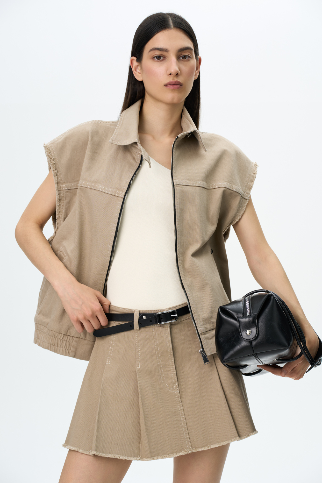 Джинсовая юбка длины мини в складку из хлопка. Потайная застежка на молнию и пуговицу. Шлевки на поясе для ремня.