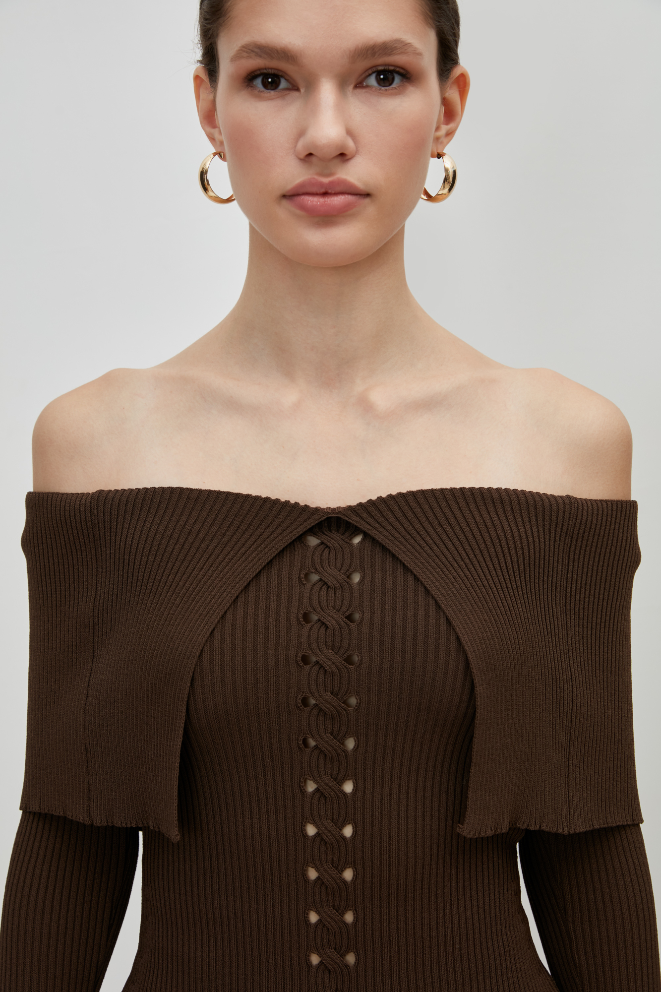 Приталенный топ из вискозы с длинным рукавом и открытыми плечами. Модель декорирована вывязанным орнаментом в виде косы и широкой отлетной деталью.