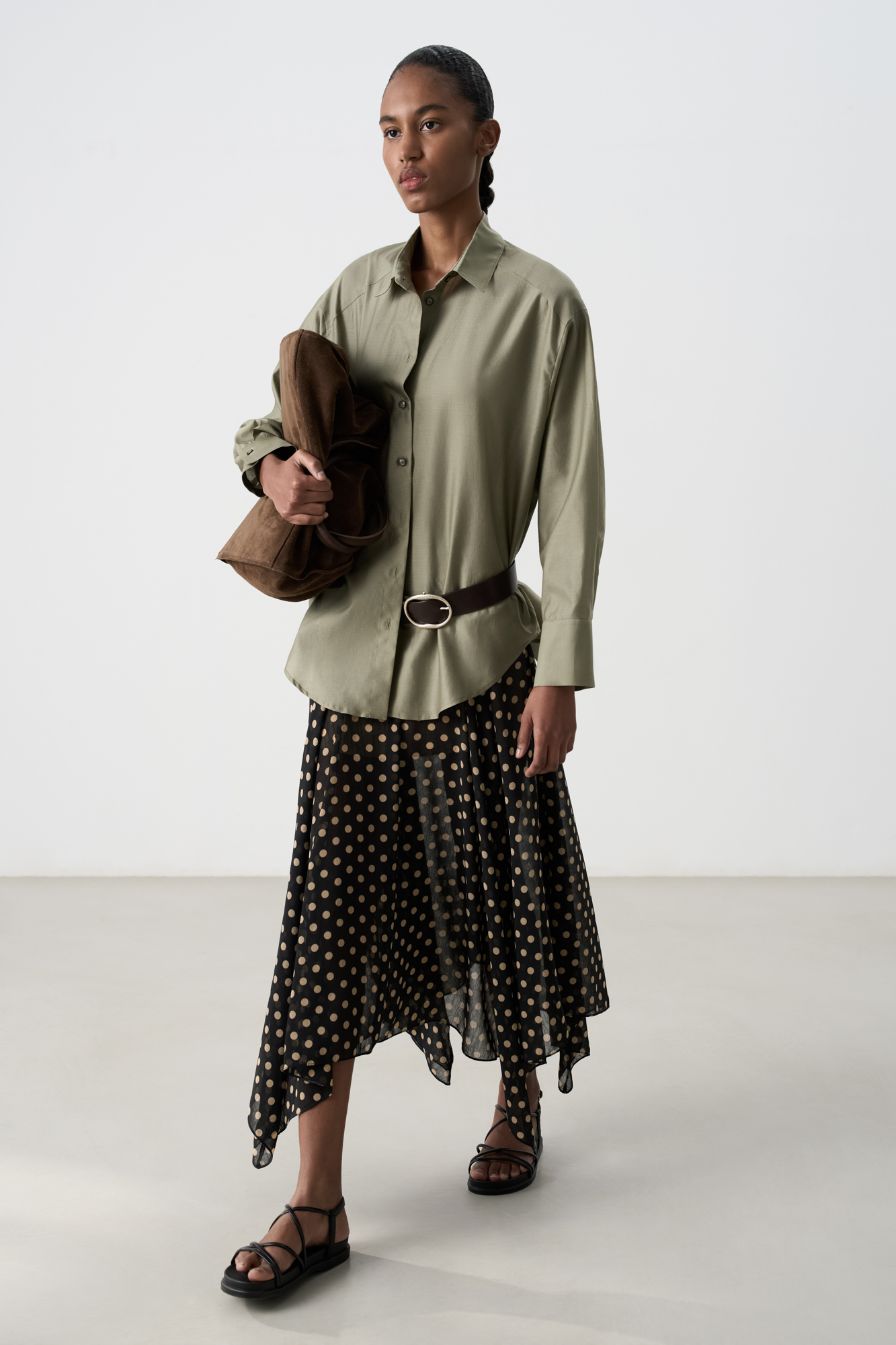 Шифоновая юбка длины миди с принтом горох. Модель А-силуэта с асимметричным подолом. Изделие выполнено на подкладке. Застежка на потайную молнию.