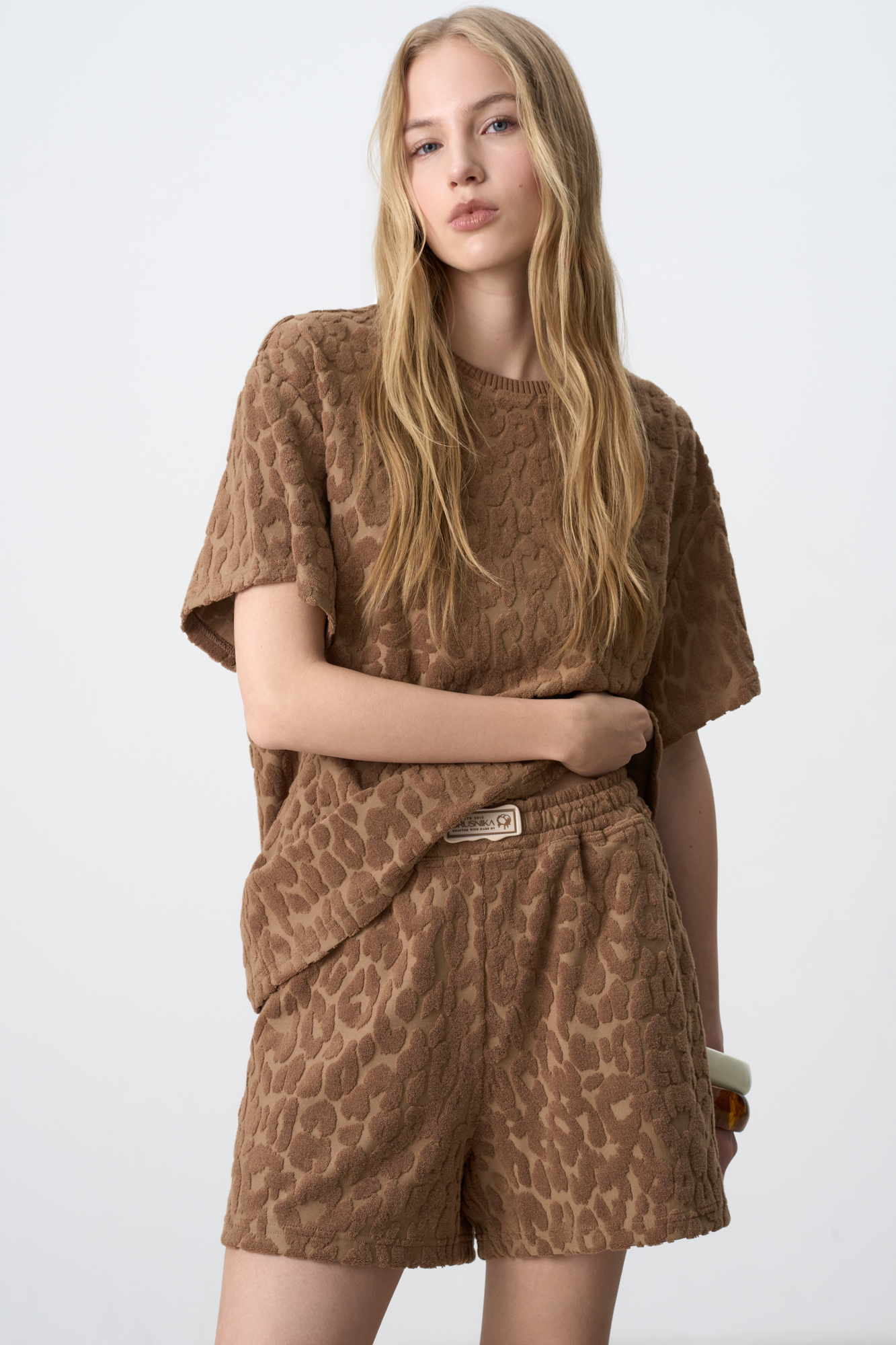 Шорты из махрового трикотажа. Модель свободного силуэта с эластичным поясом на кулиске и брендированным ярлыком. Дополнить образ можно футболкой в таком же стиле.