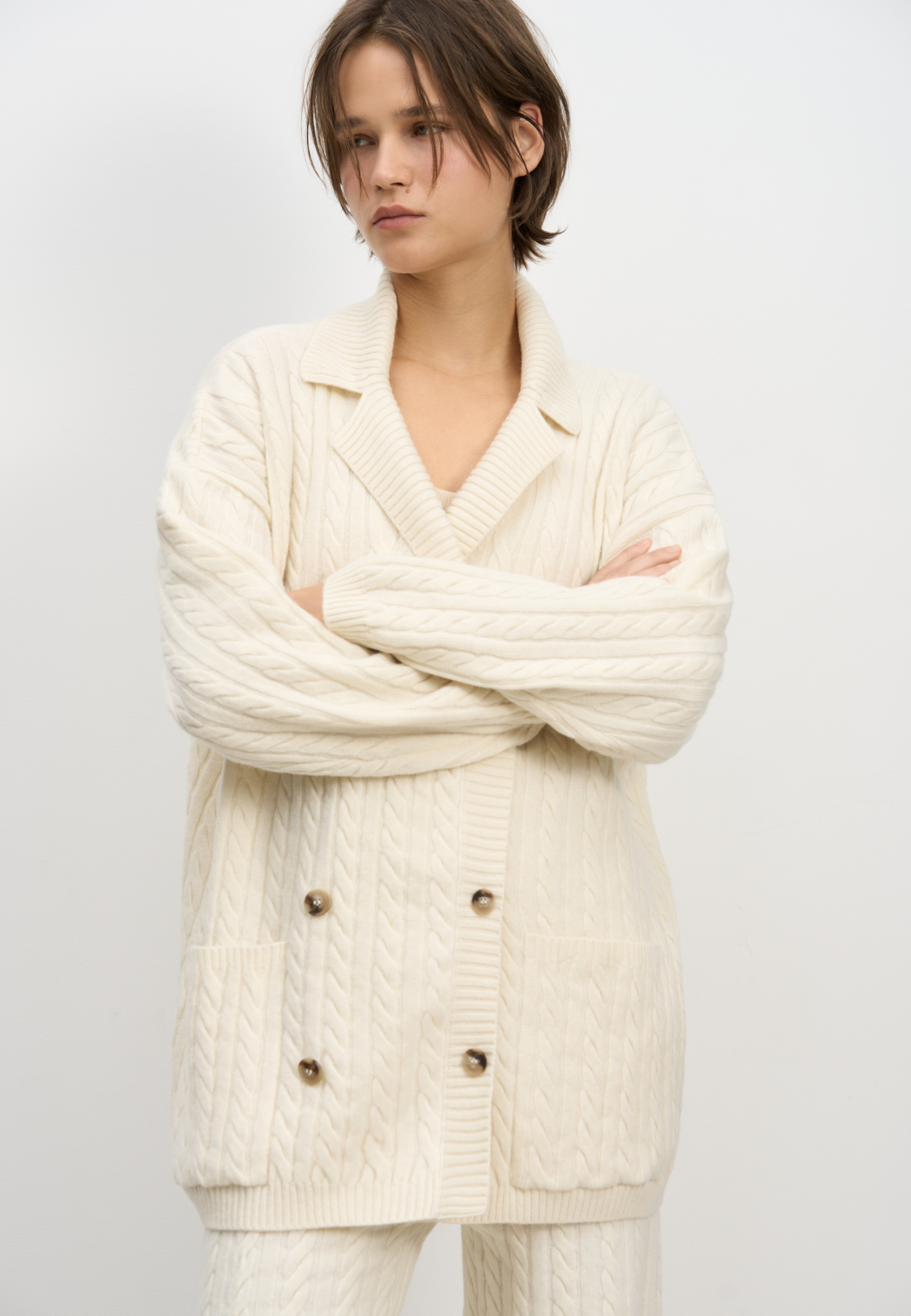 Трикотажный кардиган из кашемира и шерсти. Модель с отложным воротником и большими накладными карманами. Края изделия выполнены в широкий рубчик.