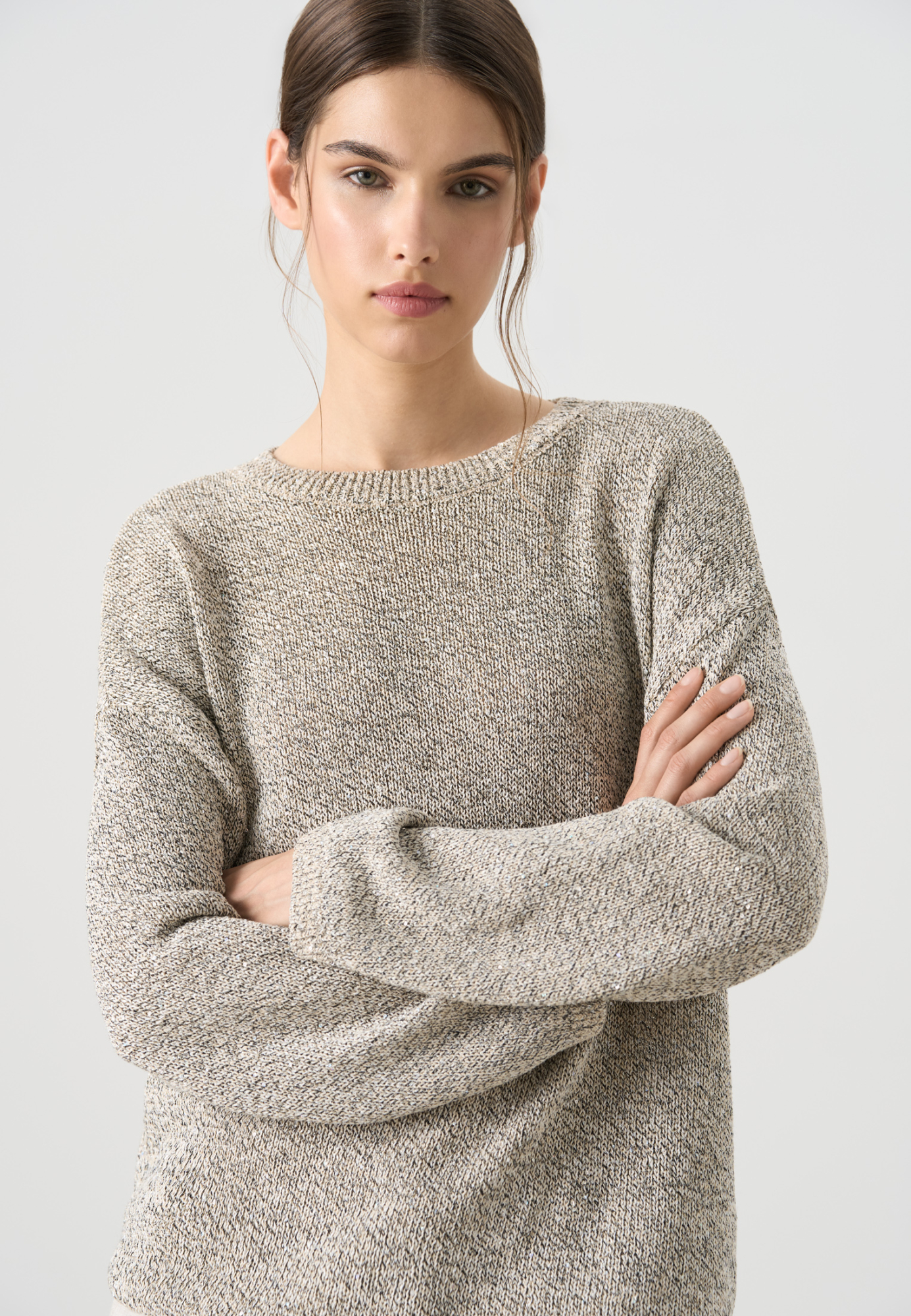 Трикотажный джемпер с голографическими пайетками. Модель свободного силуэта со спущенной линией плеча и круглой горловиной. Дополнить образ можно юбкой в таком же стиле. 