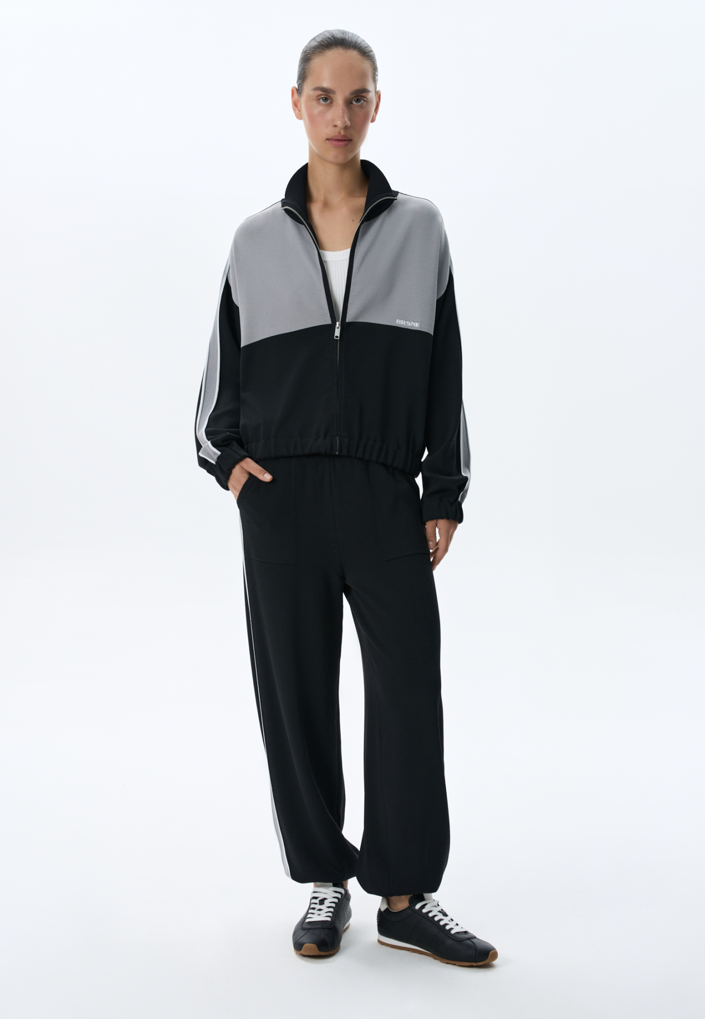 Трикотажные брюки-джоггеры из вискозы. Модель выполнена в спортивном стиле, с эластичным поясом со шнурком, боковыми карманами и манжетами на резинке. Изделие декорировано широкими лампасами контрастного цвета. 