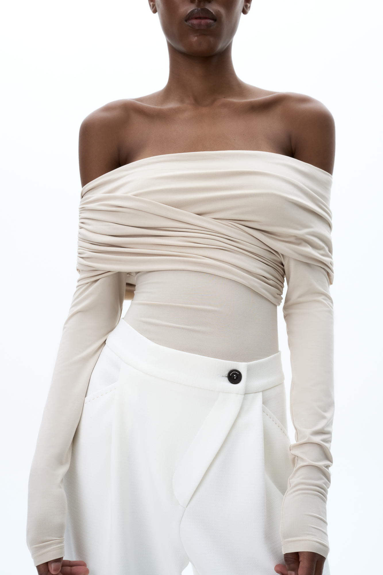 Боди из модала с драпировкой на груди. Модель приталенного силуэта, с длинным рукавом, открытой линией плеч и застежкой на бельевые крючки.