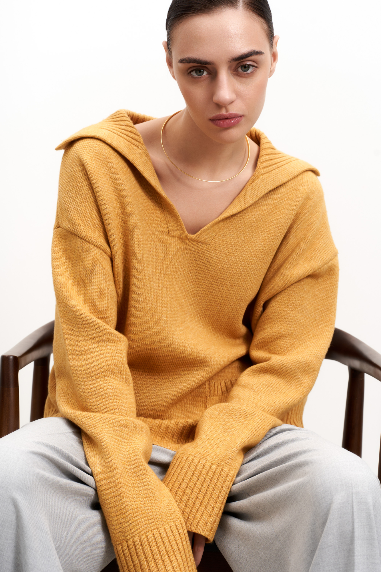 Трикотажный джемпер из шерсти с V-образным вырезом и отложным воротником. Модель свободного силуэта с накладными карманами.