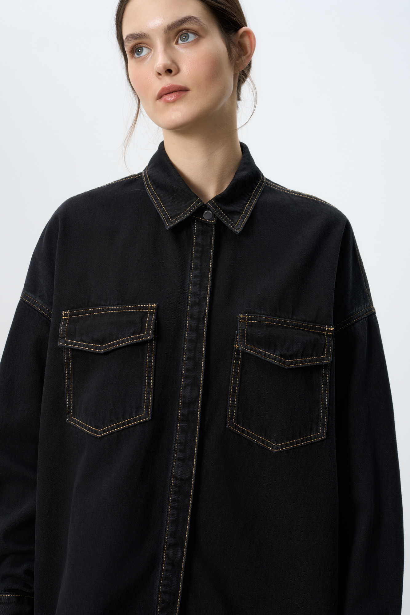 Джинсовая рубашка из 100% хлопка. Модель свободного силуэта, с длинными рукавами, отложным воротником и накладными карманами на груди с клапанами. Застежка на магнитные пуговицы. Изделие декорировано вставкой из кружева на спине.