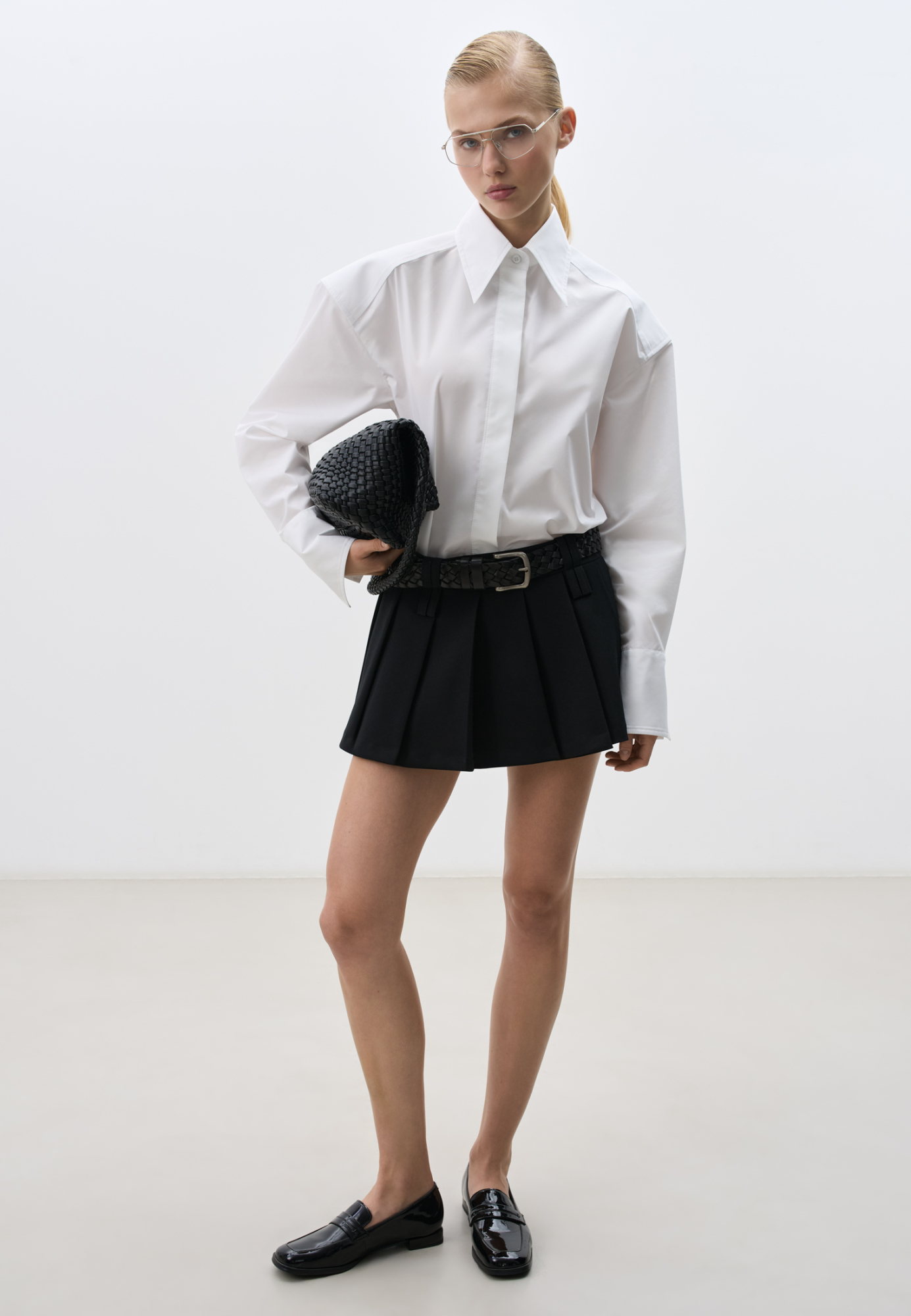 Юбка длины мини в складку из поливискозы. Модель с широким поясом и двойными шлевками для ремня. Застежка на потайную молнию. Изделие выполнено на подкладке из вискозы в виде шортиков.