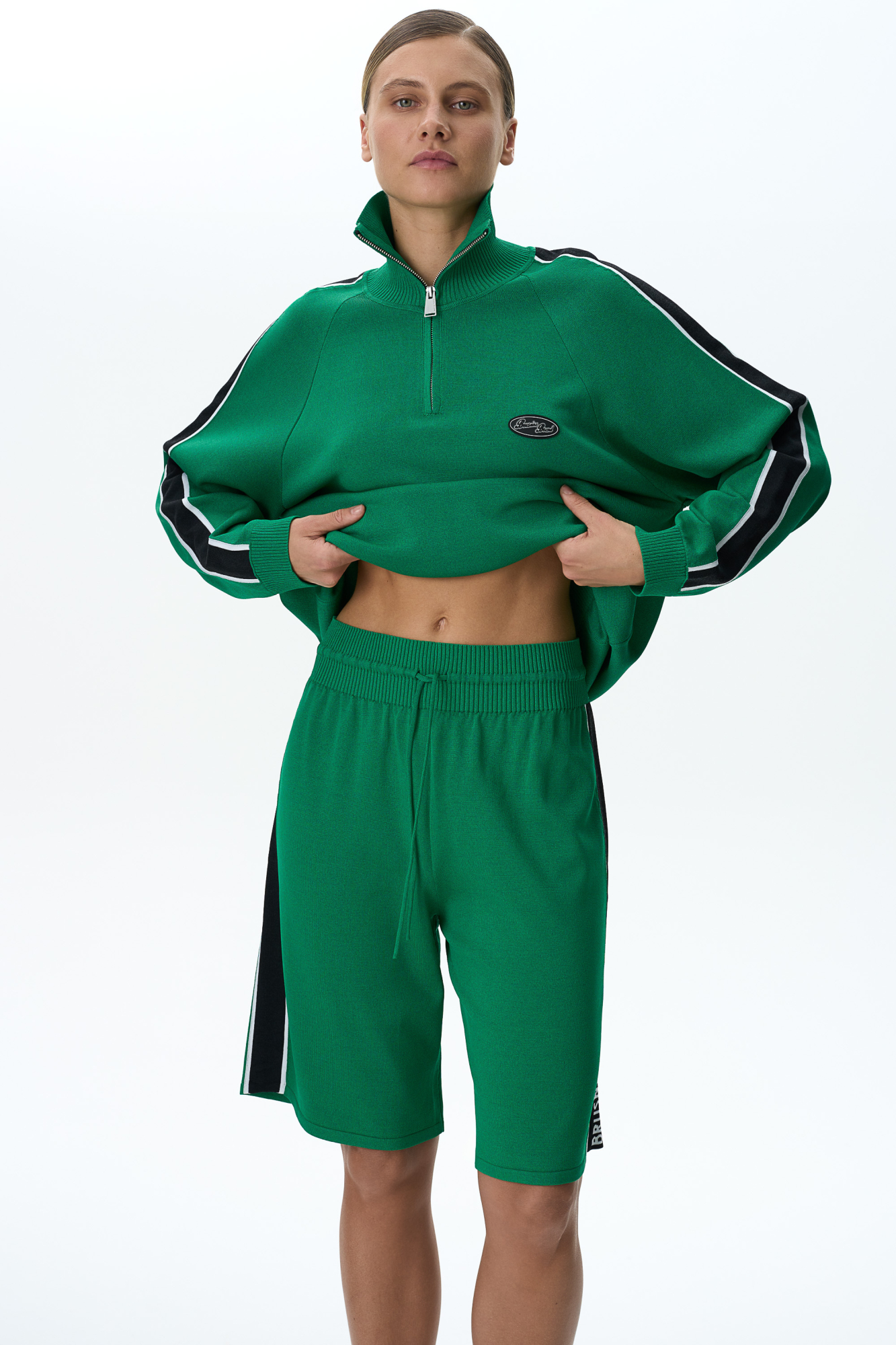 Трикотажные шорты в спортивном стиле с широким двухцветным лампасом. Пояс с кулиской на эластичной ленте в рубчик. Дополнить образ можно джемпером в таком же стиле.