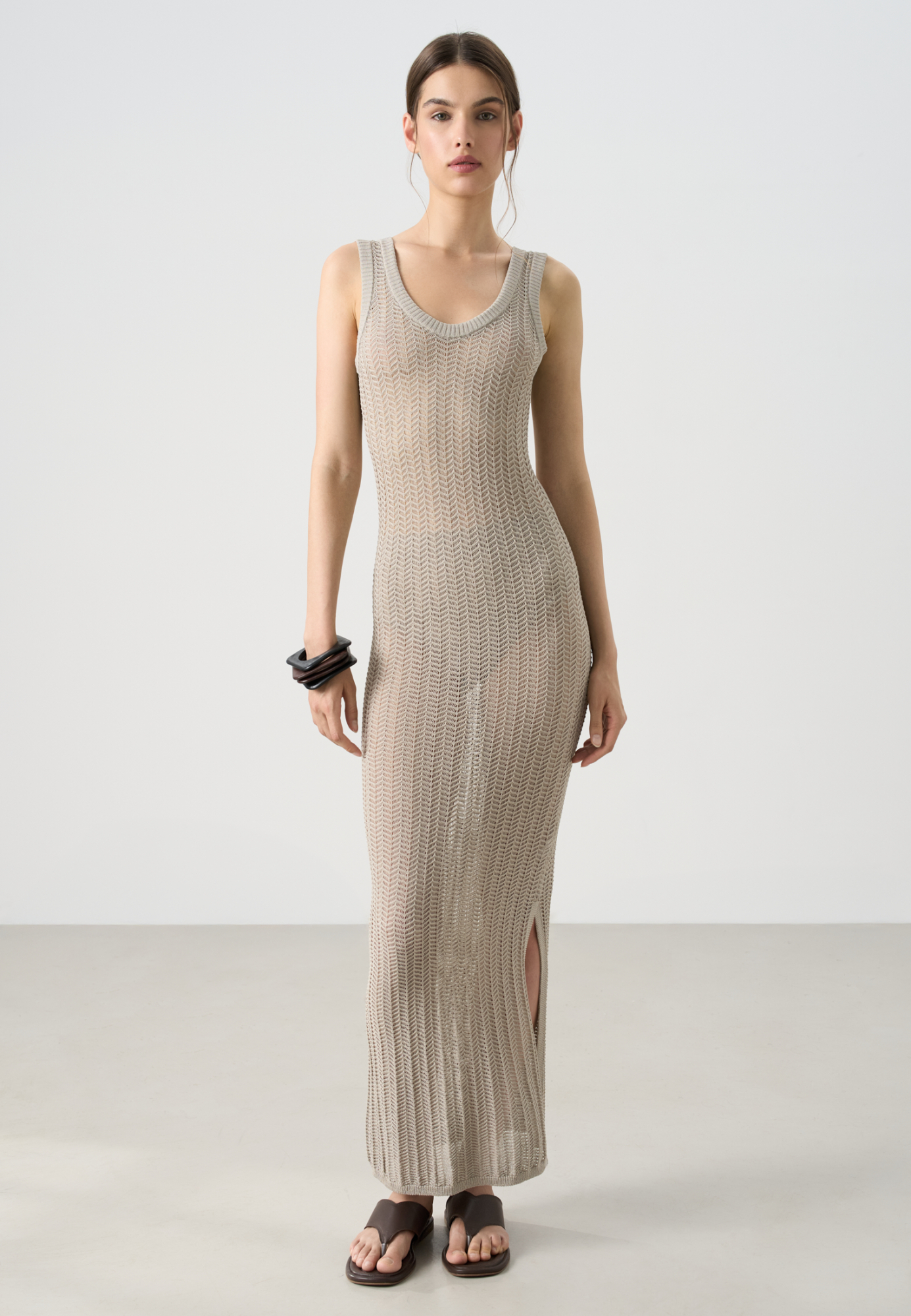 Трикотажный ажурный сарафан из вискозы. Модель свободного силуэта, без рукавов, на тонких бретельках и открытой спиной. Вязка выполнена узором "ёлочка", края изделия выполнены в рубчик.