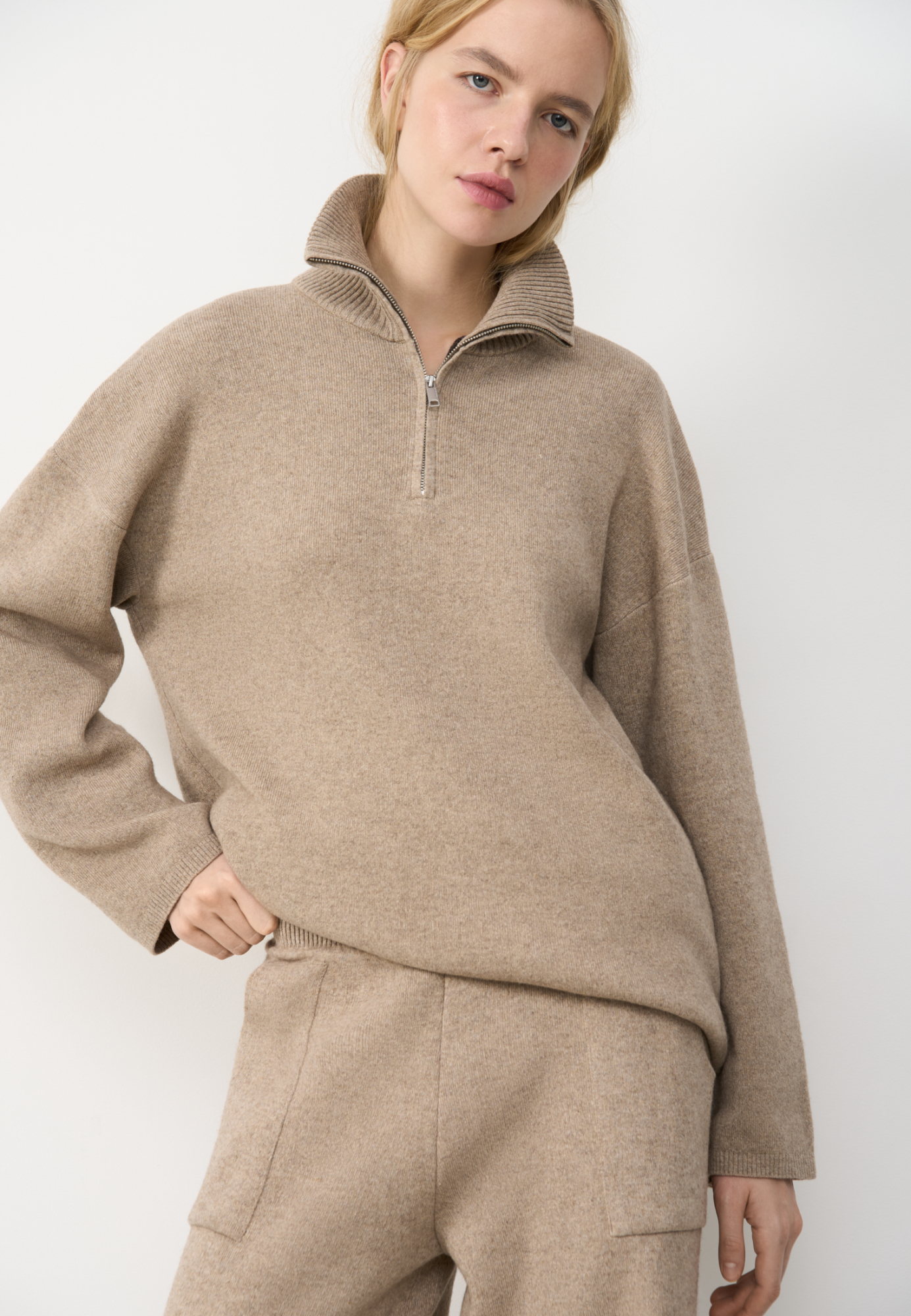 Трикотажный джемпер из кашемира и шерсти. Модель свободного кроя, с высоким воротом на молнии и спущенной линией плеч. Ворот и края изделия выполнены в рубчик. 