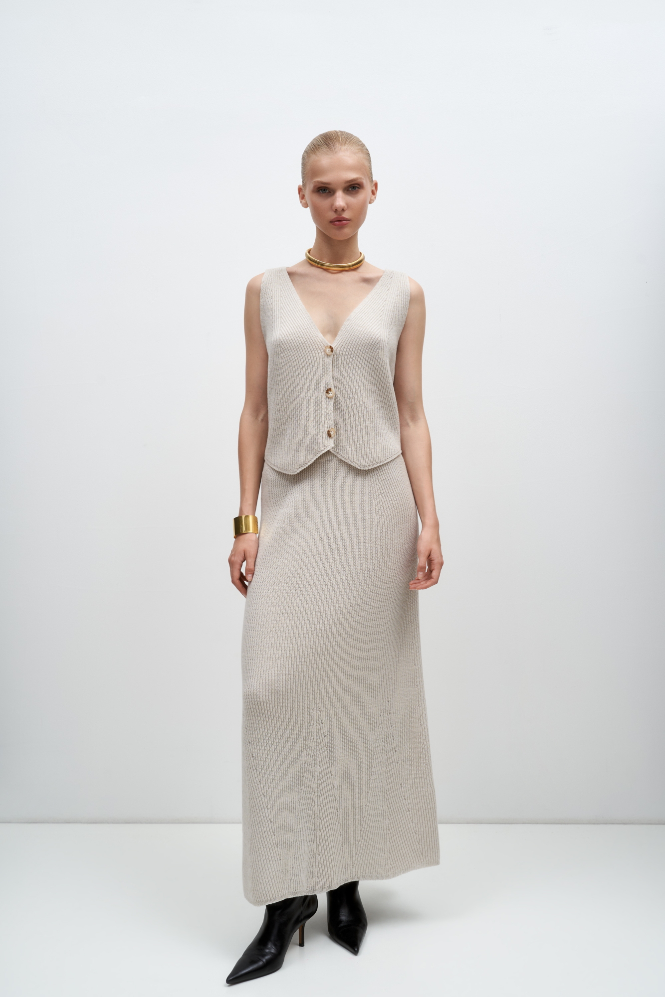 Трикотажная юбка длины макси из шерсти. Модель свободного силуэта с эластичным поясом в рубчик. Дополнить образ можно жилетом в таком же стиле.