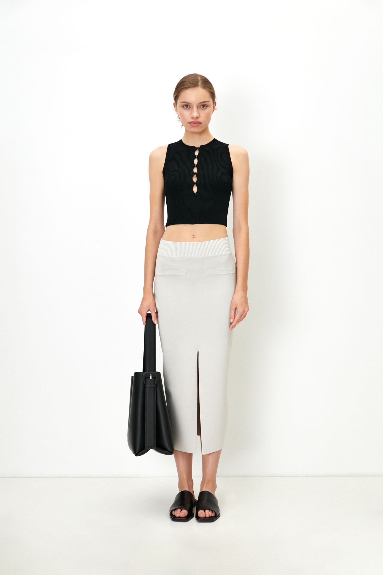 Трикотажная юбка-карандаш длины миди из вискозы. Модель приталенного силуэта с разрезом спереди, задними карманами и широким эластичным поясом.
