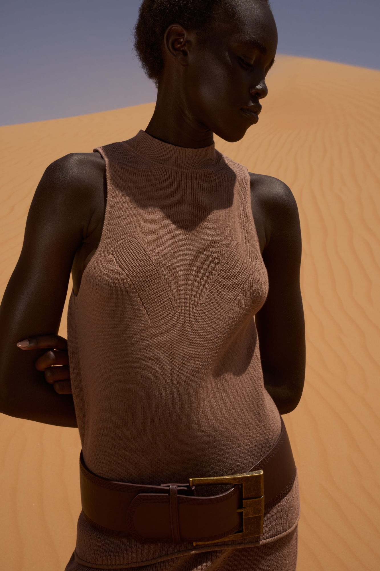 Трикотажный топ из хлопка с добавлением вискозы. Модель с высоким воротником-стойкой и глубокой проймой. Воротник изделия выполнен в мелкий рубчик. 