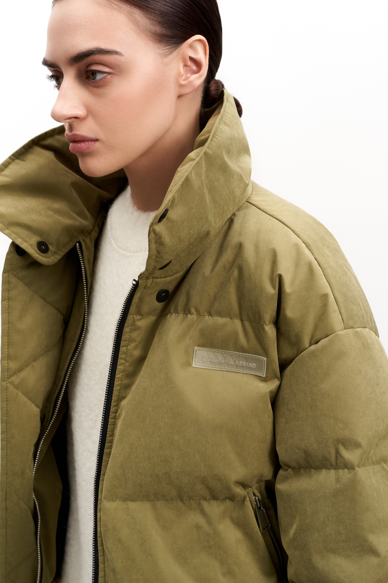 Утепленный пуховик с воротником-стойкой и капюшоном на молнии. Модель свободного силуэта с боковыми карманами, спущенным плечом и брендированным ярлыком на груди. Застежка на потайную молнию и кнопки. Наполнитель натуральный пух 90% перо 10%.