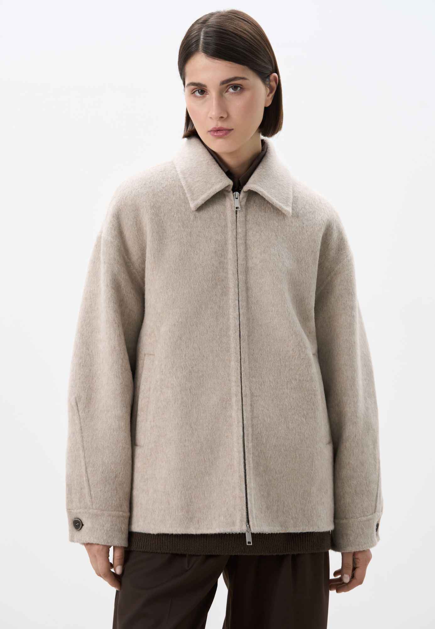 Куртка на молнии из мягкой шерстяной ткани с добавлением верблюжьей шерсти и шелка. Модель свободного кроя с отложным воротником, спущенной линией плеч и двумя боковыми карманами. Застежка на молнию. При пошиве этого изделия была использована технология double face, благодаря которой внутренняя сторона выглядит также аккуратно, как и внешняя.