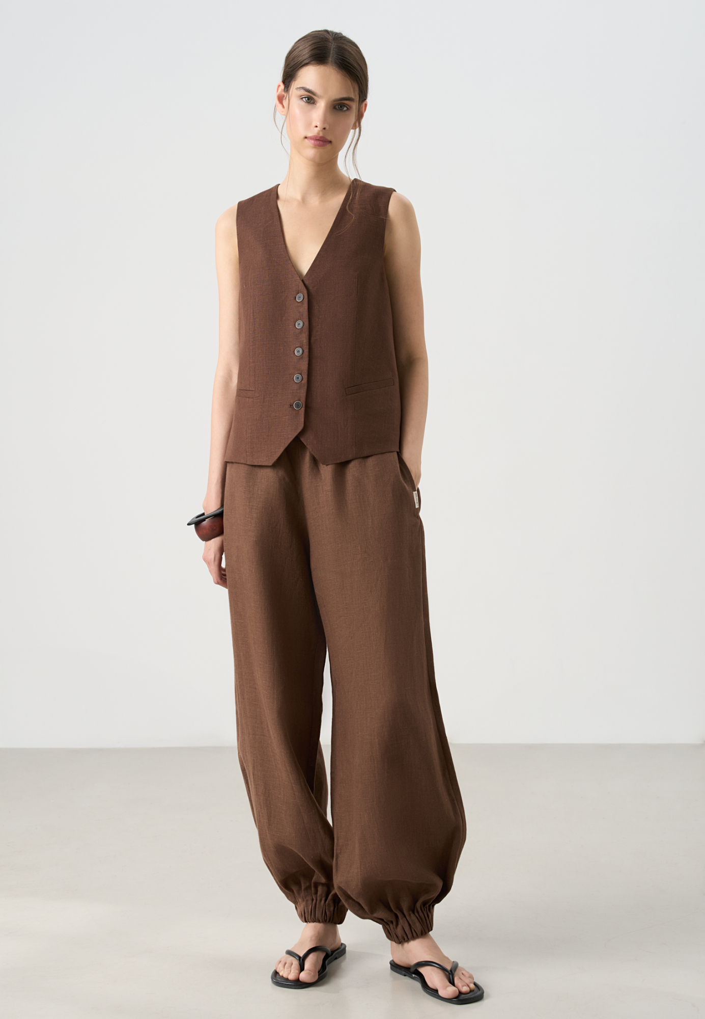 Классический жилет из 100% льна. Модель прямого кроя, с V-образным вырезом, карманами и застежкой на пуговицы.