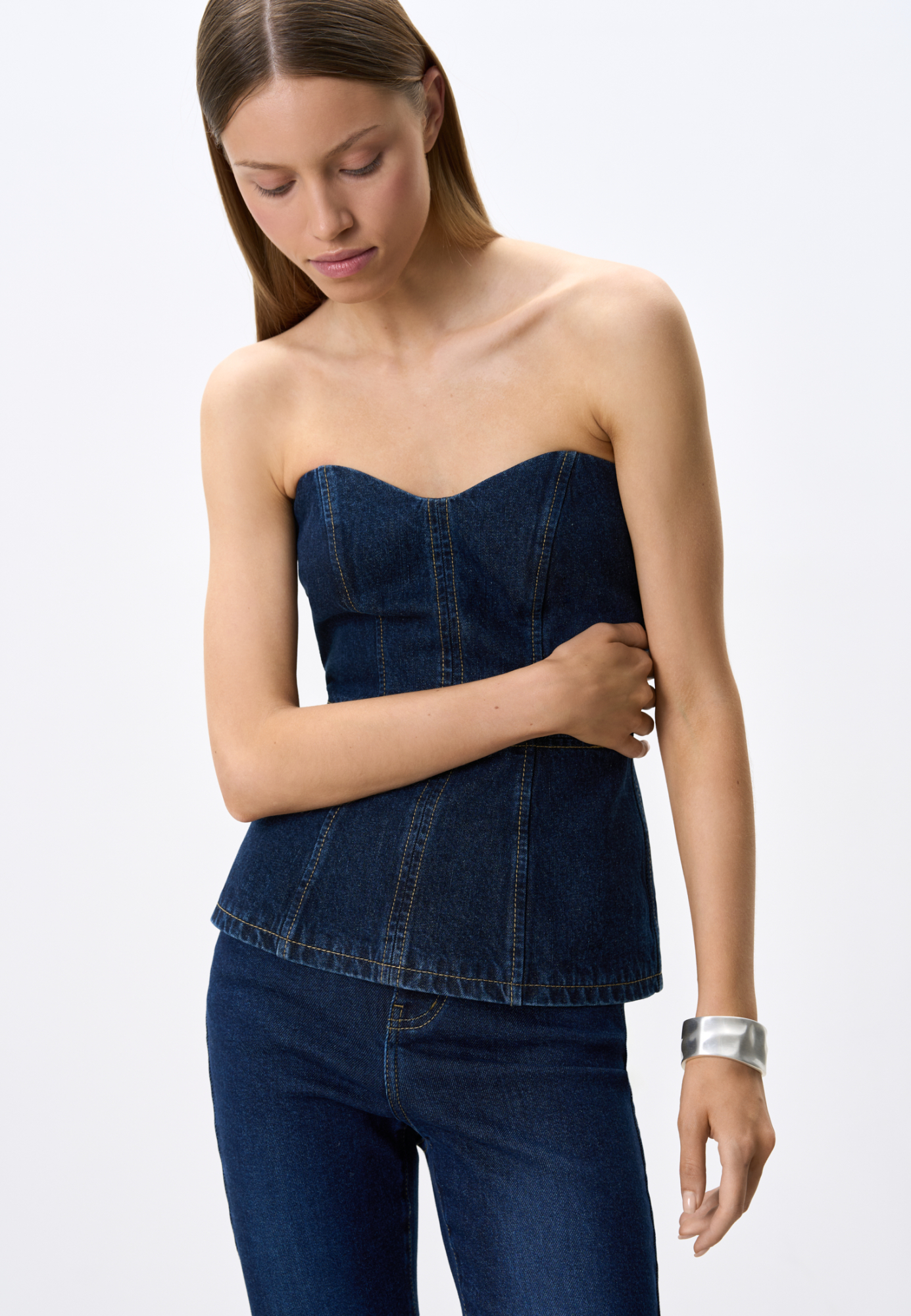 Джинсовый корсет из 100% хлопка. Модель имеет фактурный лиф и расклешеннный книзу силуэт. Изделие&nbsp;&nbsp;декорировано строчкой контрастного цвета. Застежка на молнию сзади.