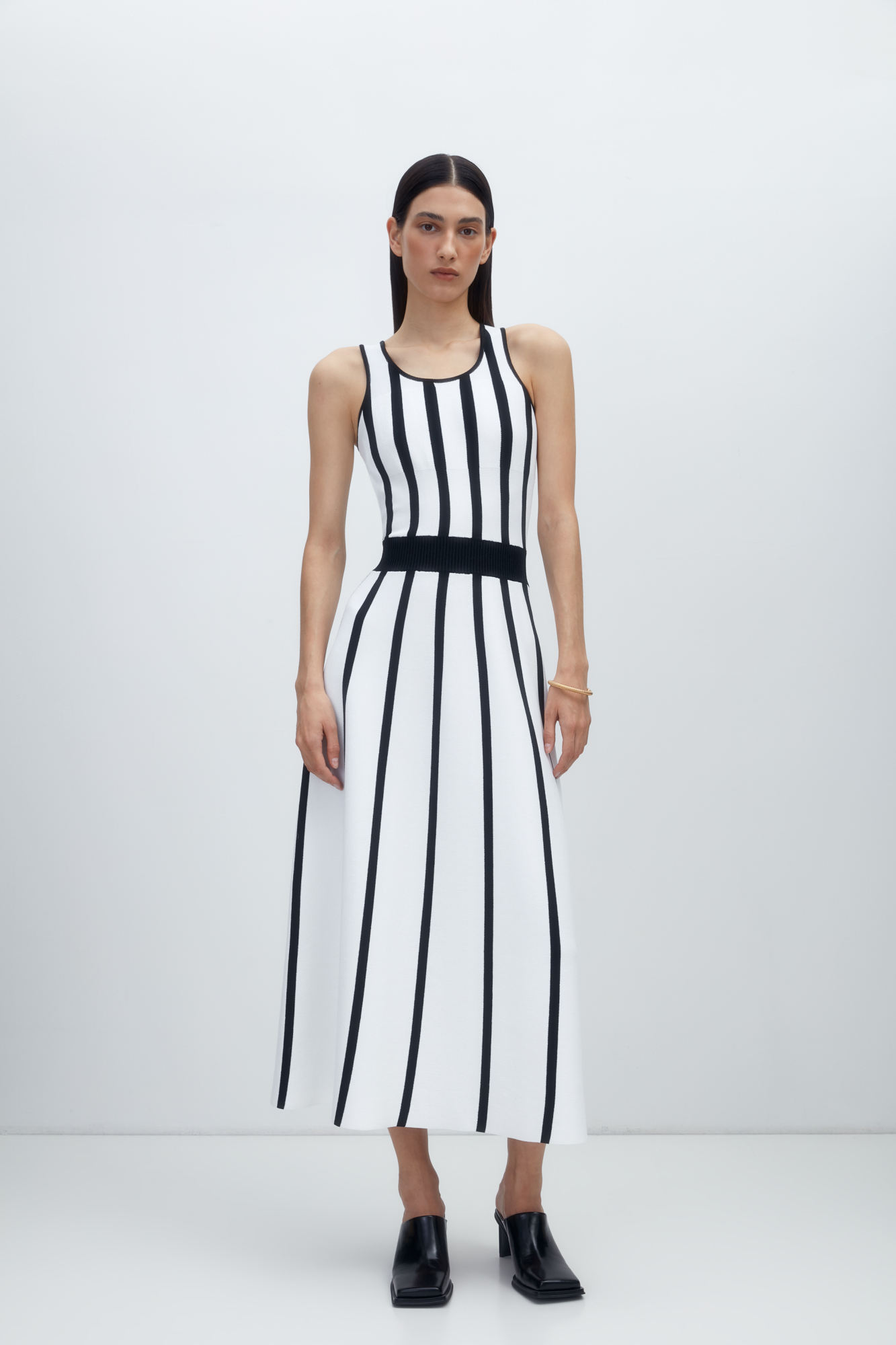 Трикотажное платье длины миди из вискозы. Модель приталенного силуэта с широким эластичным поясом в рубчик.