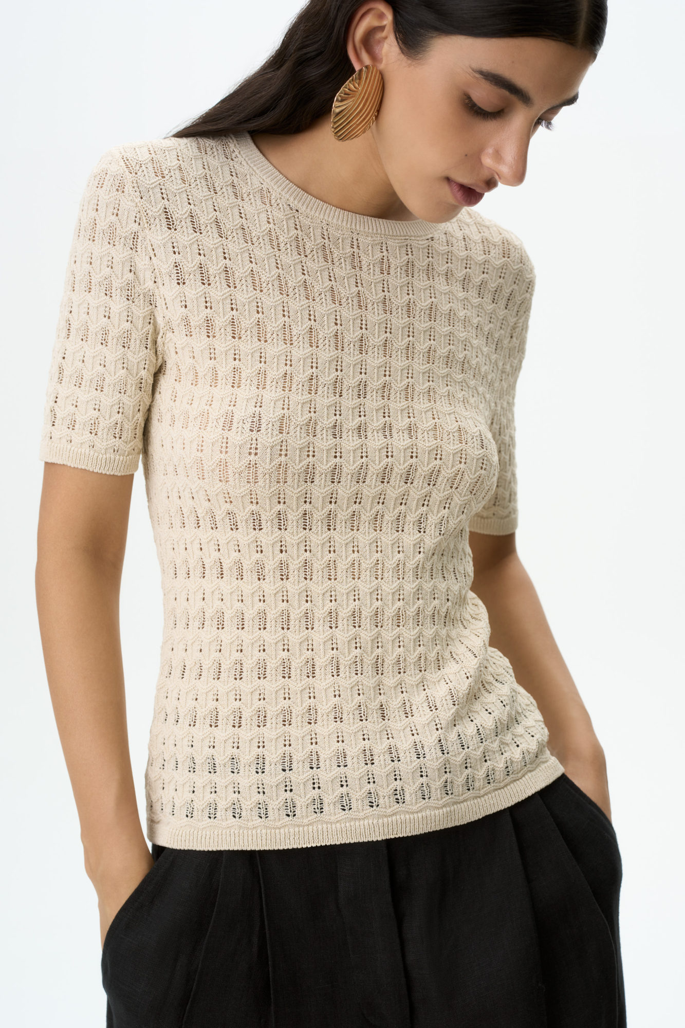 Трикотажная футболка из вискозы. Модель приталенного силуэта, с коротким рукавом, спущенной линией плеча и круглым вырезом горловины. Модель выполнена ажурным переплетением. 