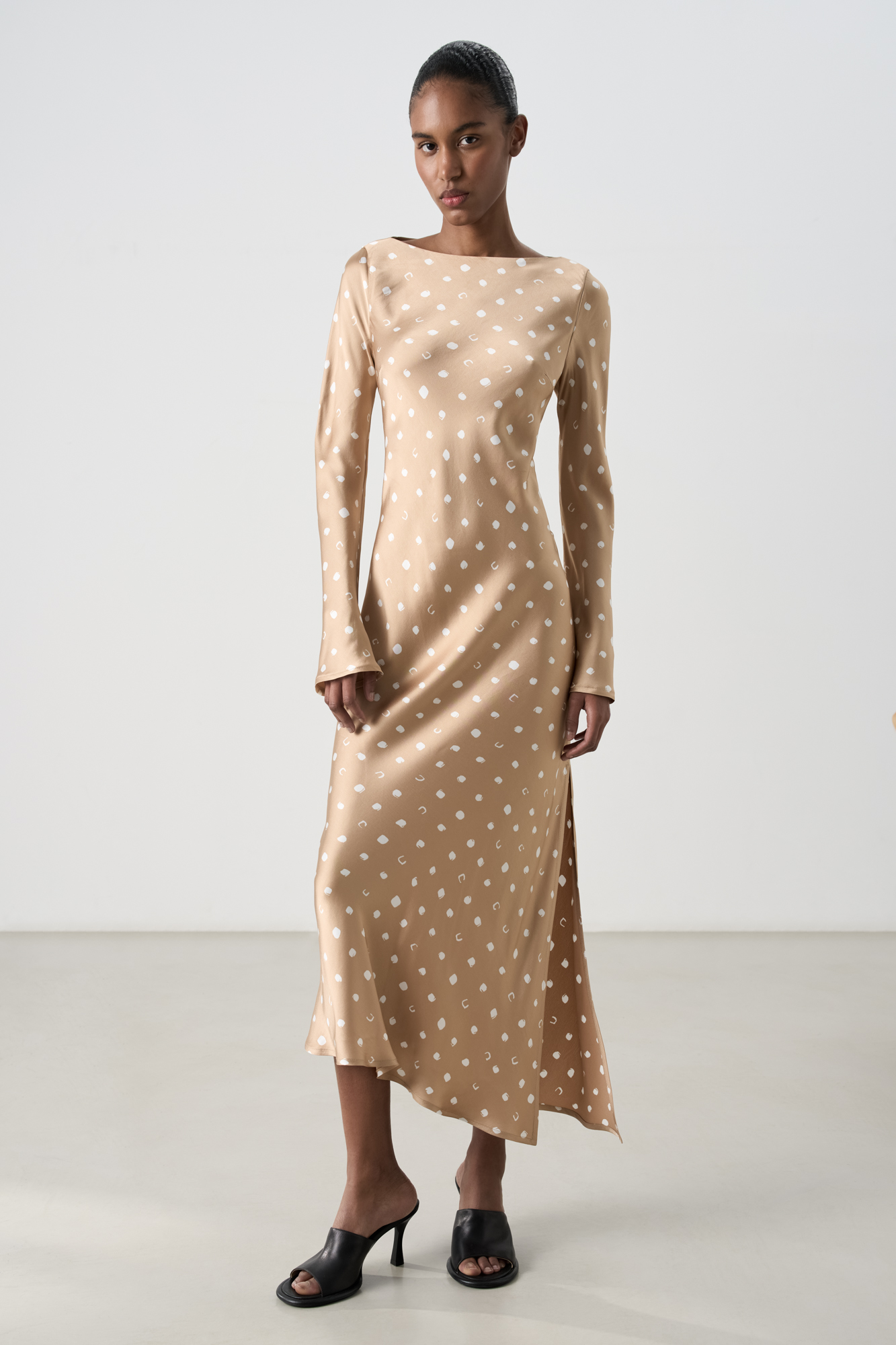 Платье длины миди из атласной 100% вискозы. Модель приталенного силуэта, с круглым вырезом горловины и длинными расклешенными рукавами. Боковой разрез. Застежка на потайную молнию сбоку.