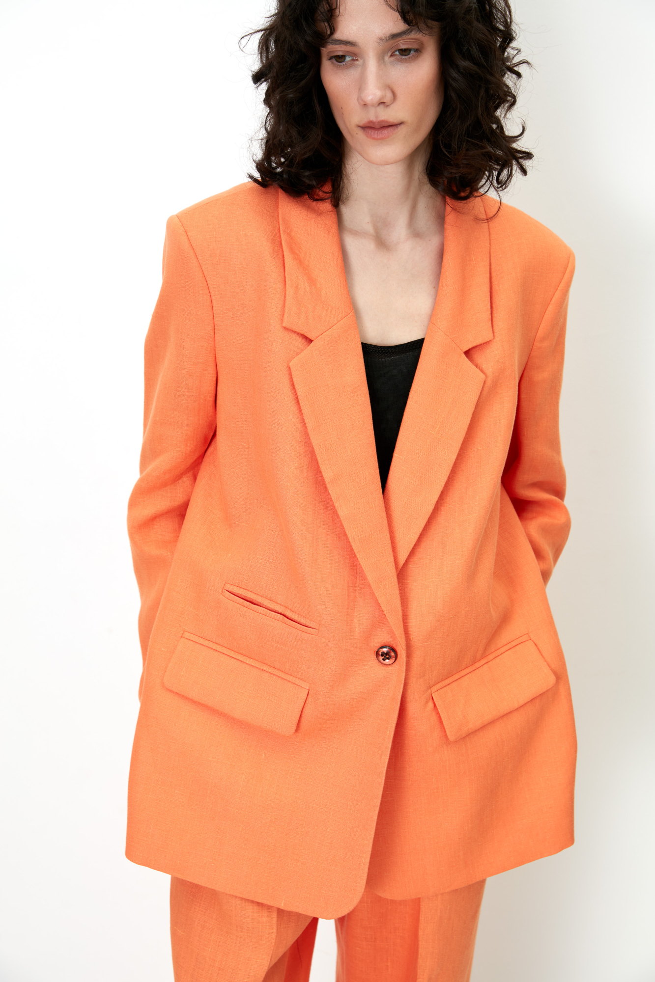 Классический жакет из 100% льна с разрезами по бокам и накладными карманами. Застежка на одну пуговицу. Изделие на подкладке.