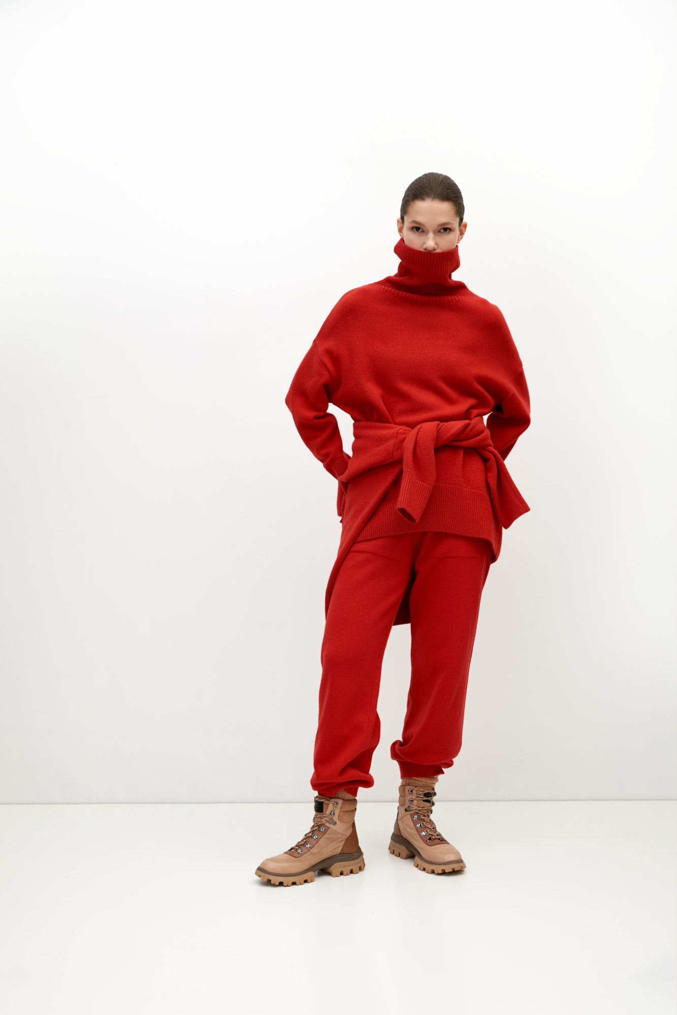 Трикотажный джемпер из мягкой шерсти с добавлением кашемира. Высокий ворот, заниженная линия плеч, удлиненная спинка. Края изделия сделаны в широкий рубчик. Можно дополнить комплектными брюками.