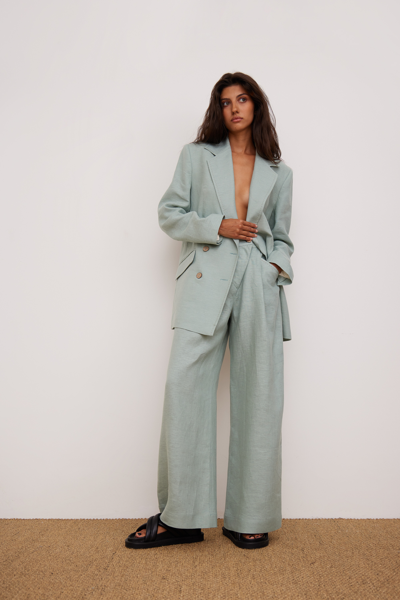 Брюки из 100% льна. Модель прямого кроя, с высокой посадкой, косой застежкой на пуговицу и молнию, боковыми карманами.