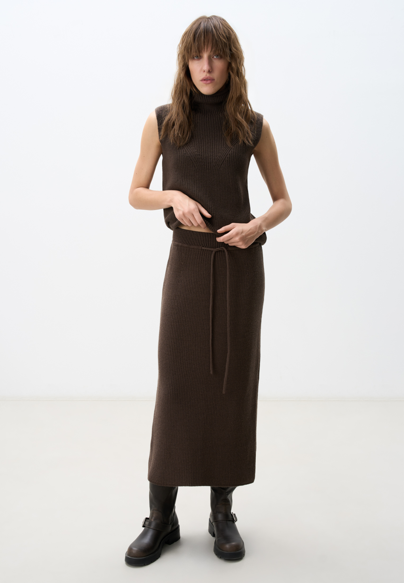 Трикотажная юбка длины миди. Модель прямого силуэта с эластичным поясом на кулиске. Дополнить образ можно жилетом в таком же стиле.