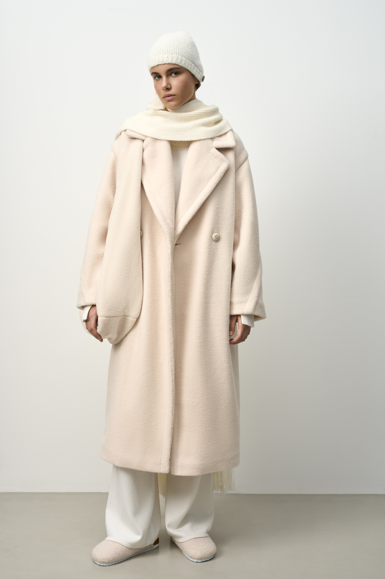 Объемная шуба из экомеха. Модель свободного силуэта с английским воротником, боковыми карманами и застежкой на пуговицы.