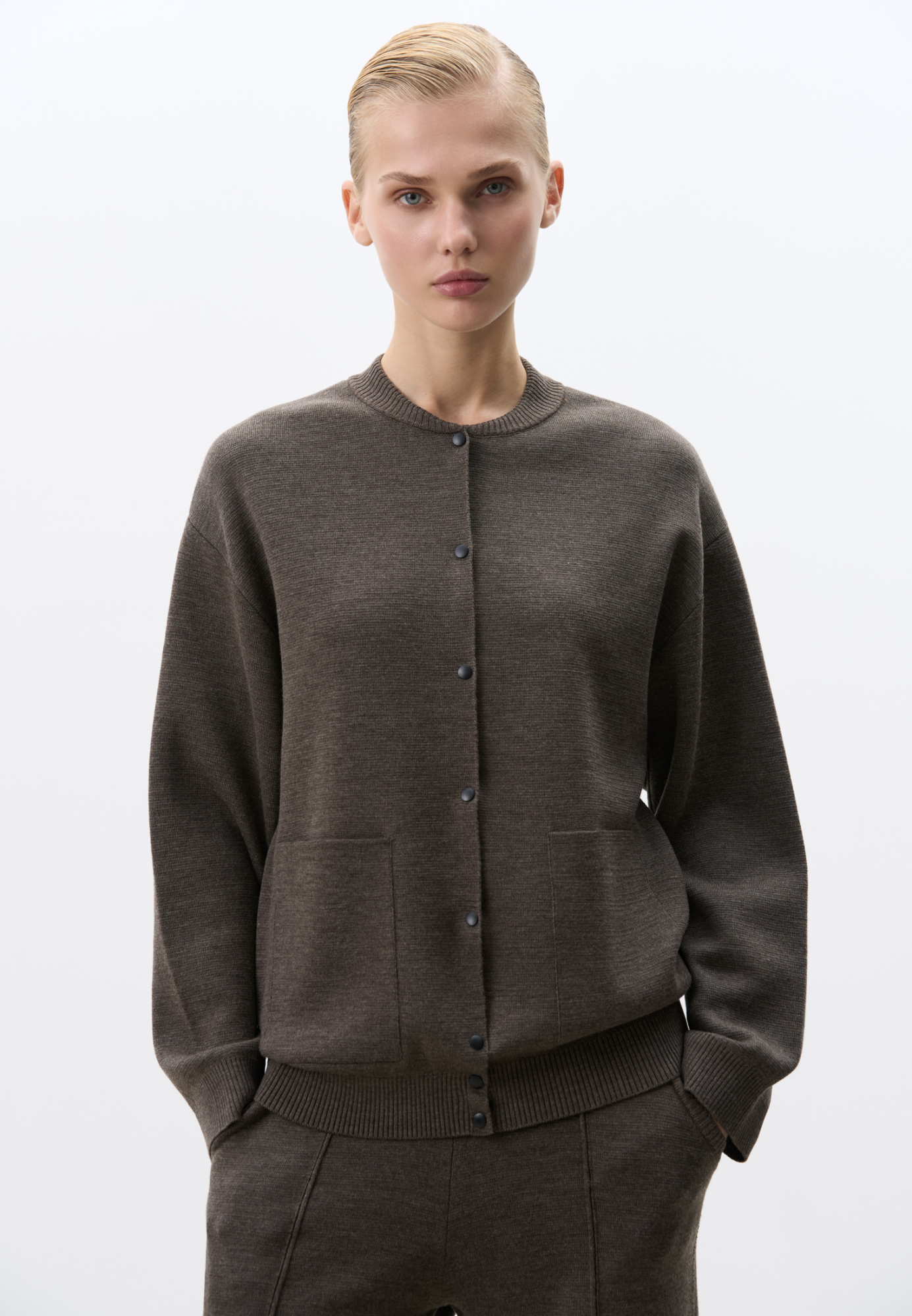 Трикотажный бомбер, в основе из шерсти мериноса. Модель свободного силуэта с накладными карманами и спущенным рукавом. Застежка на кнопки.