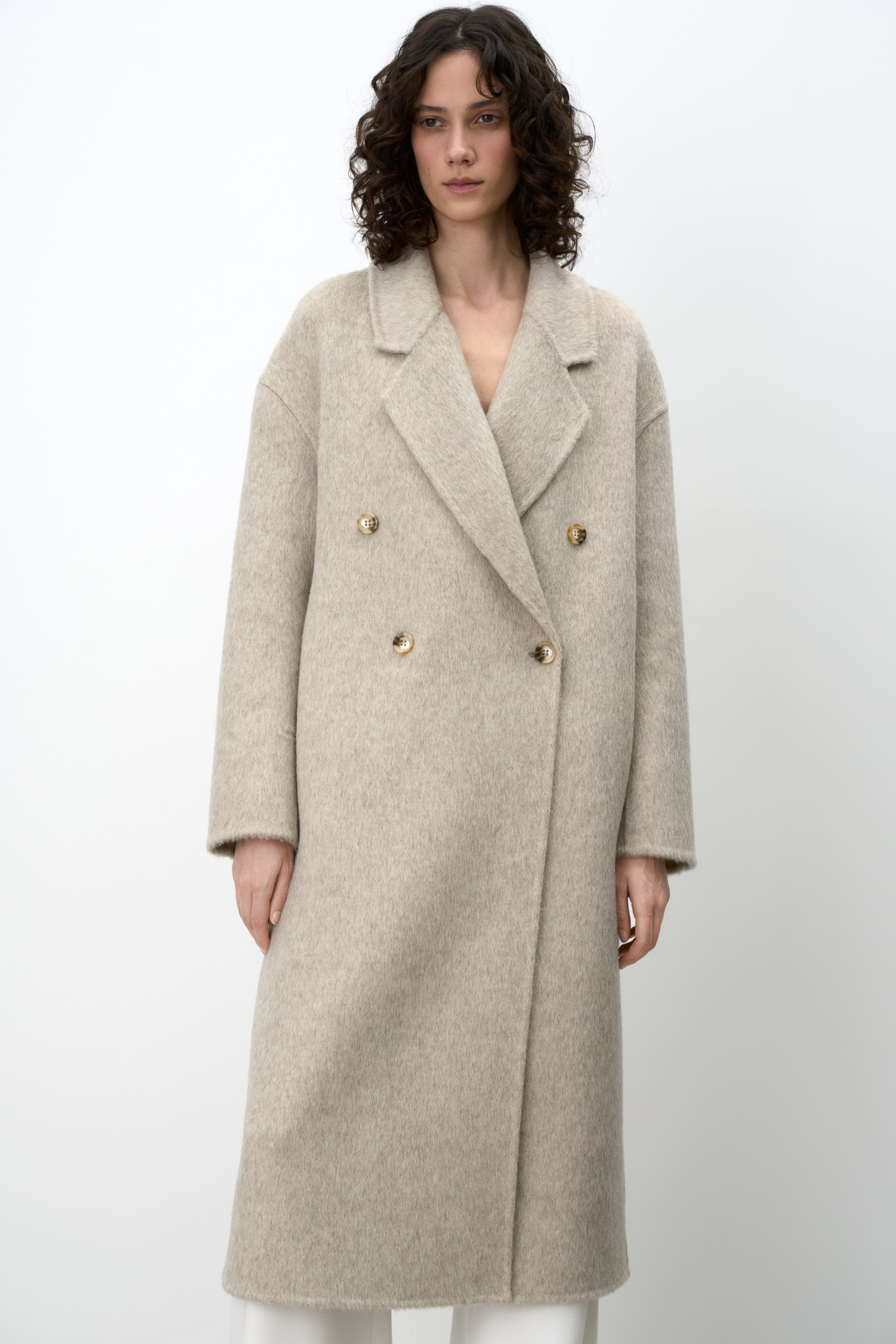 Двубортное пальто из шерсти. Модель свободного силуэта со спущенной линией плеча, отложным воротником и прямоугольными лацканами. Без подкладки.