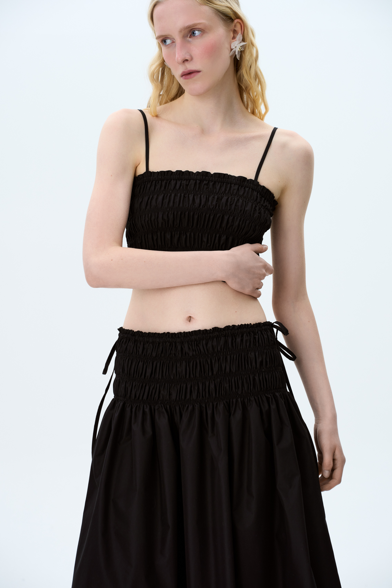 Топ&nbsp;&nbsp;с эластичными сборками на тонких регулируемых бретелях. Дополнить образ можно юбкой в таком же стиле.