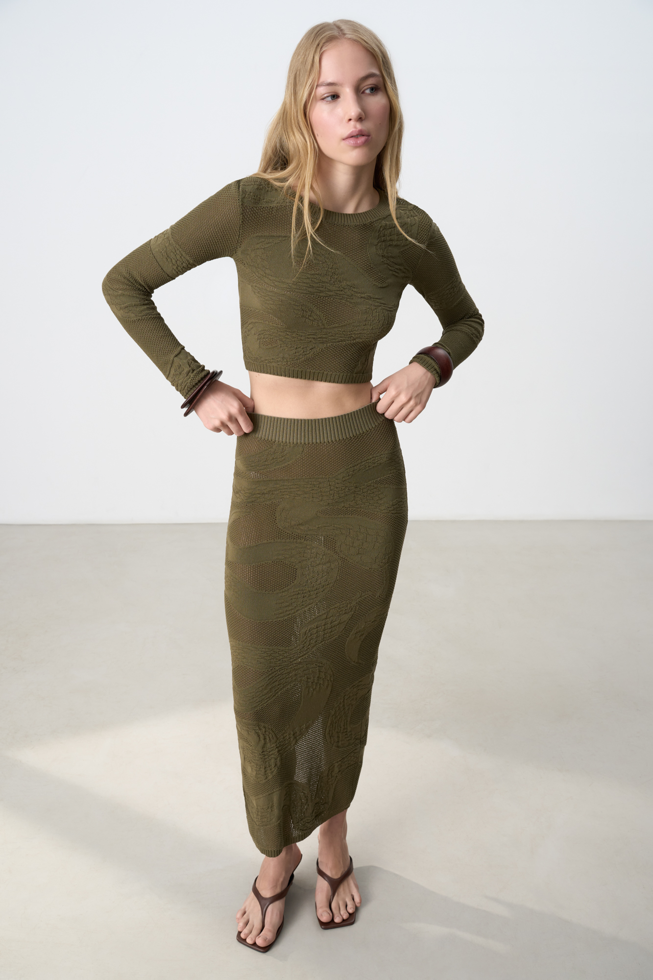 Трикотажная юбка длины макси из органического хлопка. Модель по фигуре, с широким эластичным поясом в рубчик и разрезом сзади. Изделие декорировано жаккардовым узором в виде змеи. Без подкладки.<br />
Органический хлопок - более экологичная и безопасная альтернатива обычному хлопку, выращенная без использования химикатов.