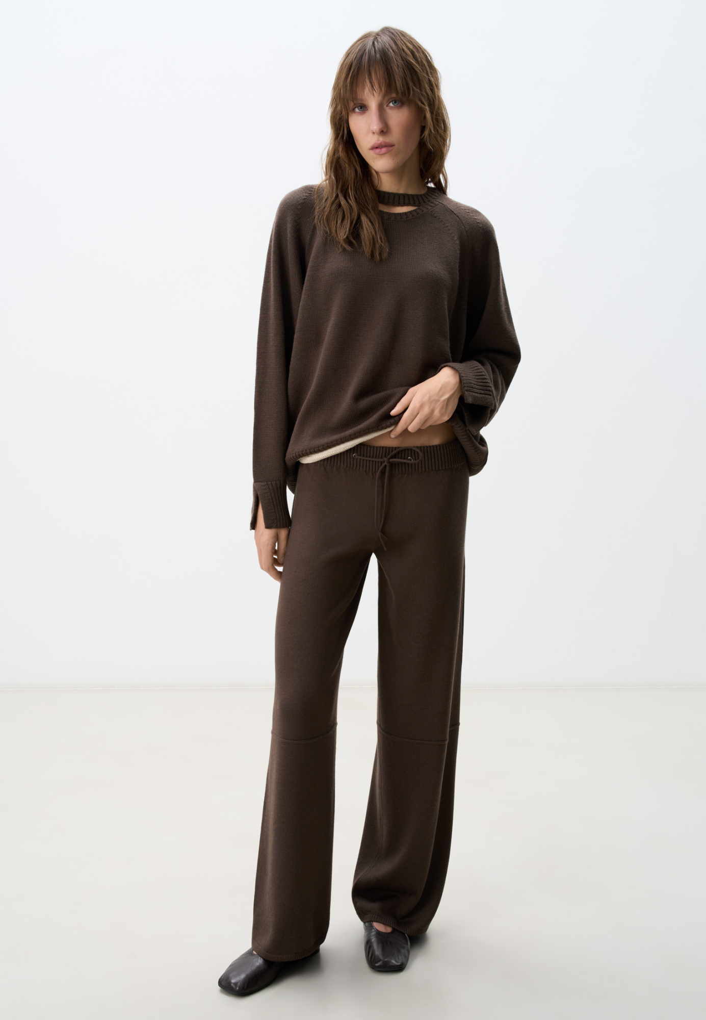 Трикотажные брюки из шерсти. Модель свободного силуэта, со средней посадкой, боковыми и задними карманами и эластичным пояс в рубчик, дополненным тонким шнурком. 