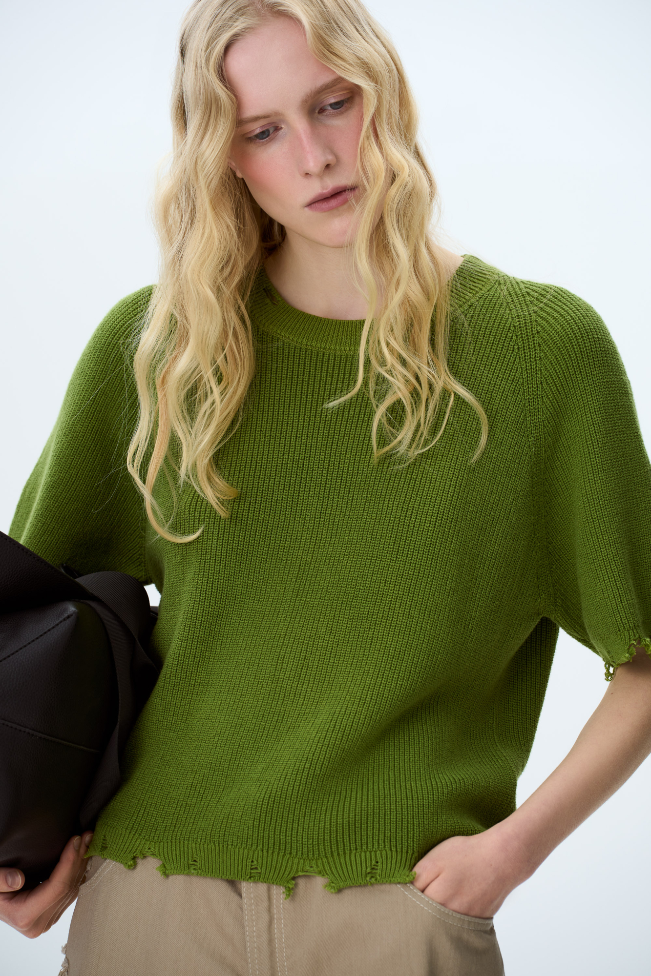 Трикотажная футболка из 100% хлопка. Модель свободного силуэта, со спущенной линией плеча, коротким рукавом и брендированным ярлыком на рукаве. Имитация необработанного края по низу изделия, на манжетах и воротнике.