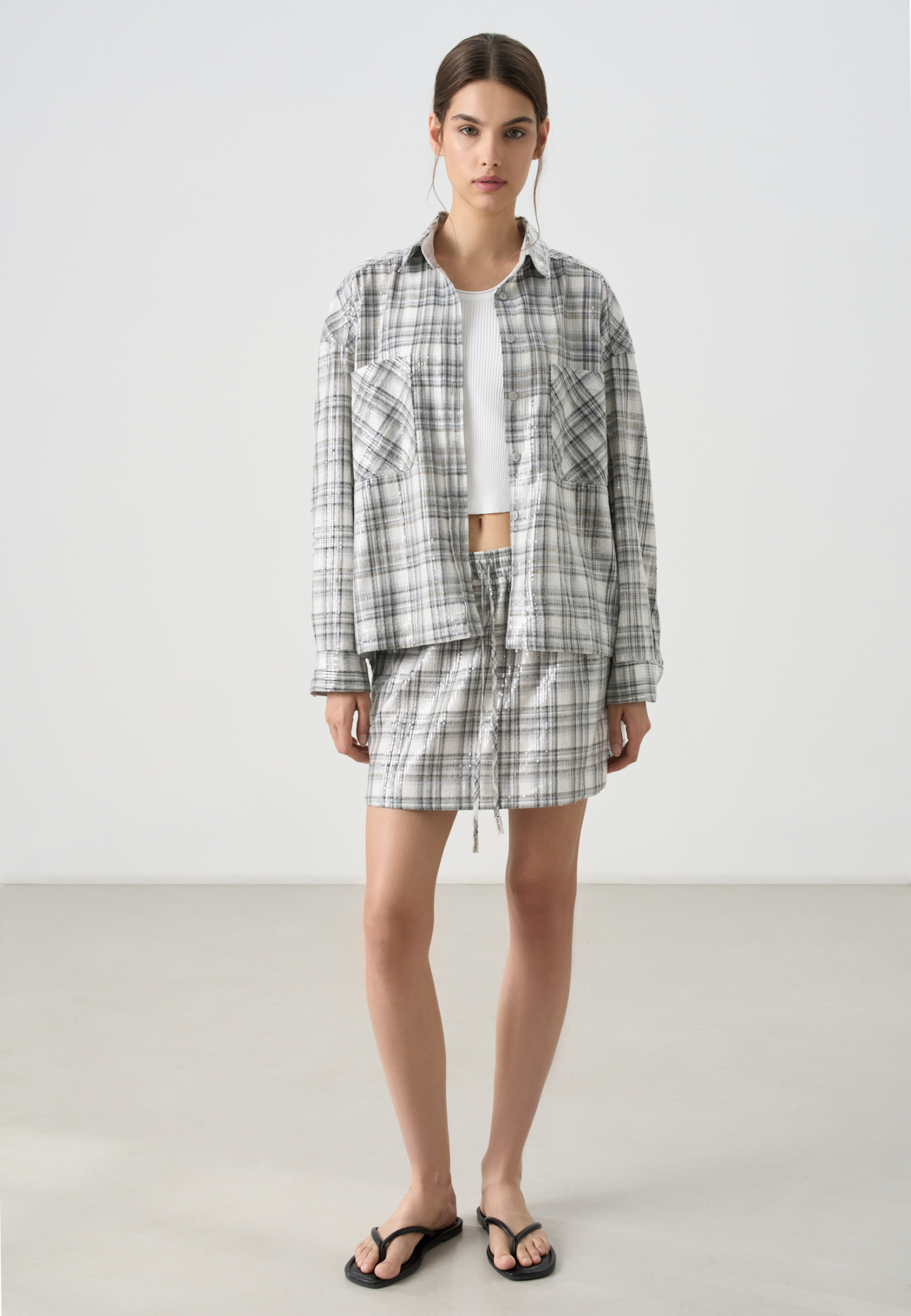 Принтованная юбка длины мини из хлопка, расшитая пайетками. Модель прямого кроя с поясом на резинке, дополненным кулиской и двумя карманами. Изделие без подкладки. Дополнить образ можно рубашкой в таком же стиле. 