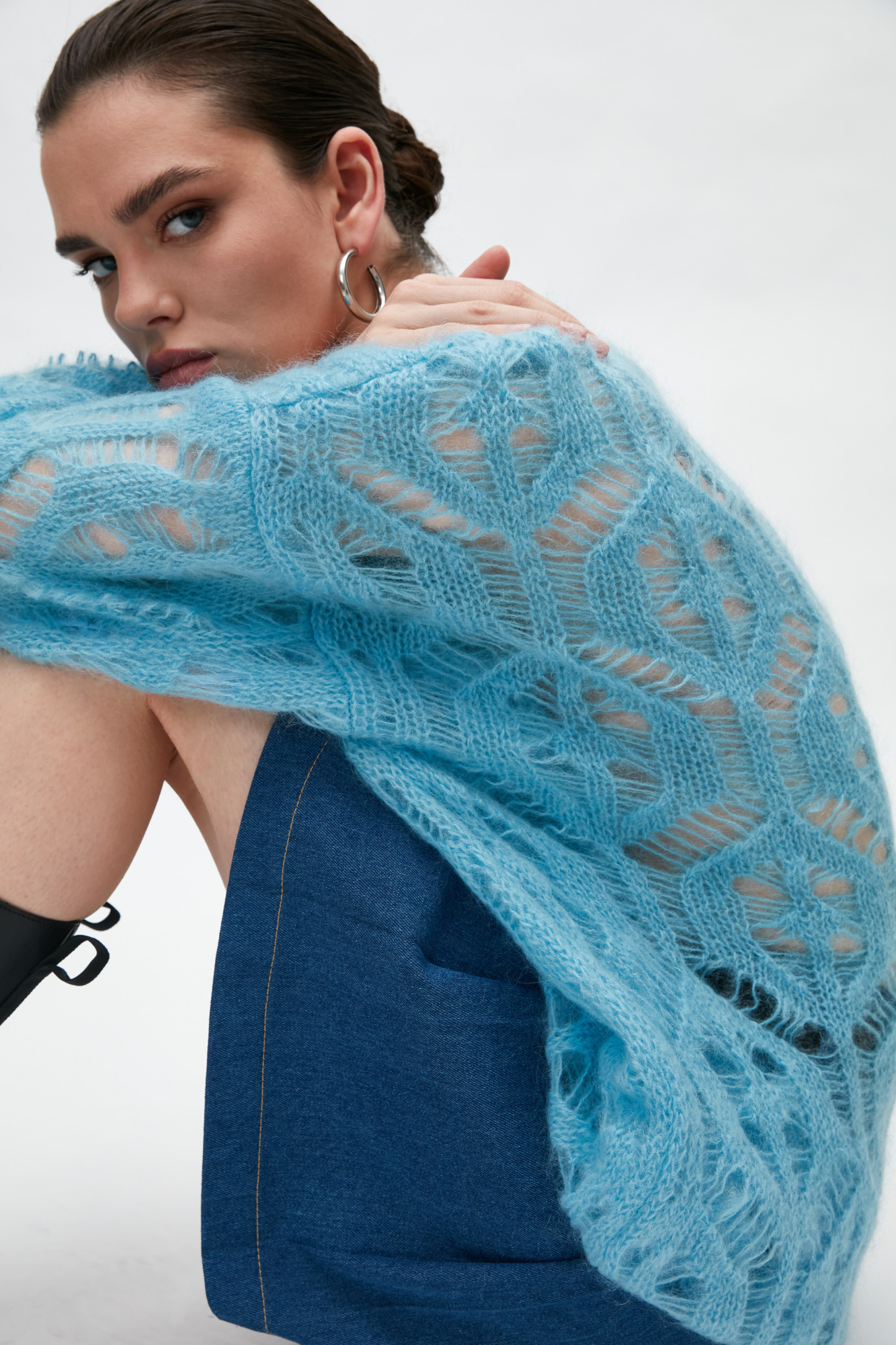 Трикотажный джемпер из мохера с добавлением шерсти. Модель свободного силуэта со спущенным плечом выполненная ажурным переплетением. Края изделия в рубчик.