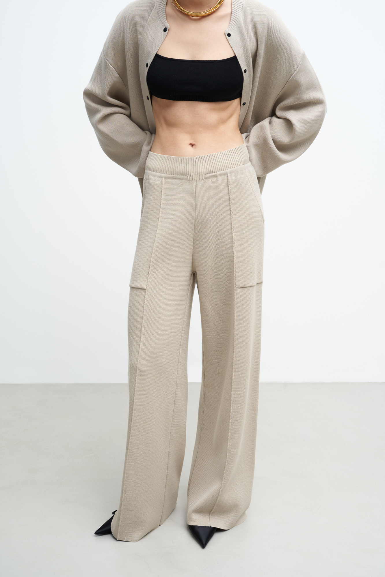Трикотажные брюки в основе из шерсти мериноса. Модель свободного силуэта со стрелками, боковыми карманами и эластичным поясом. Дополнить образ можно комплектными жилетом и бомбером.