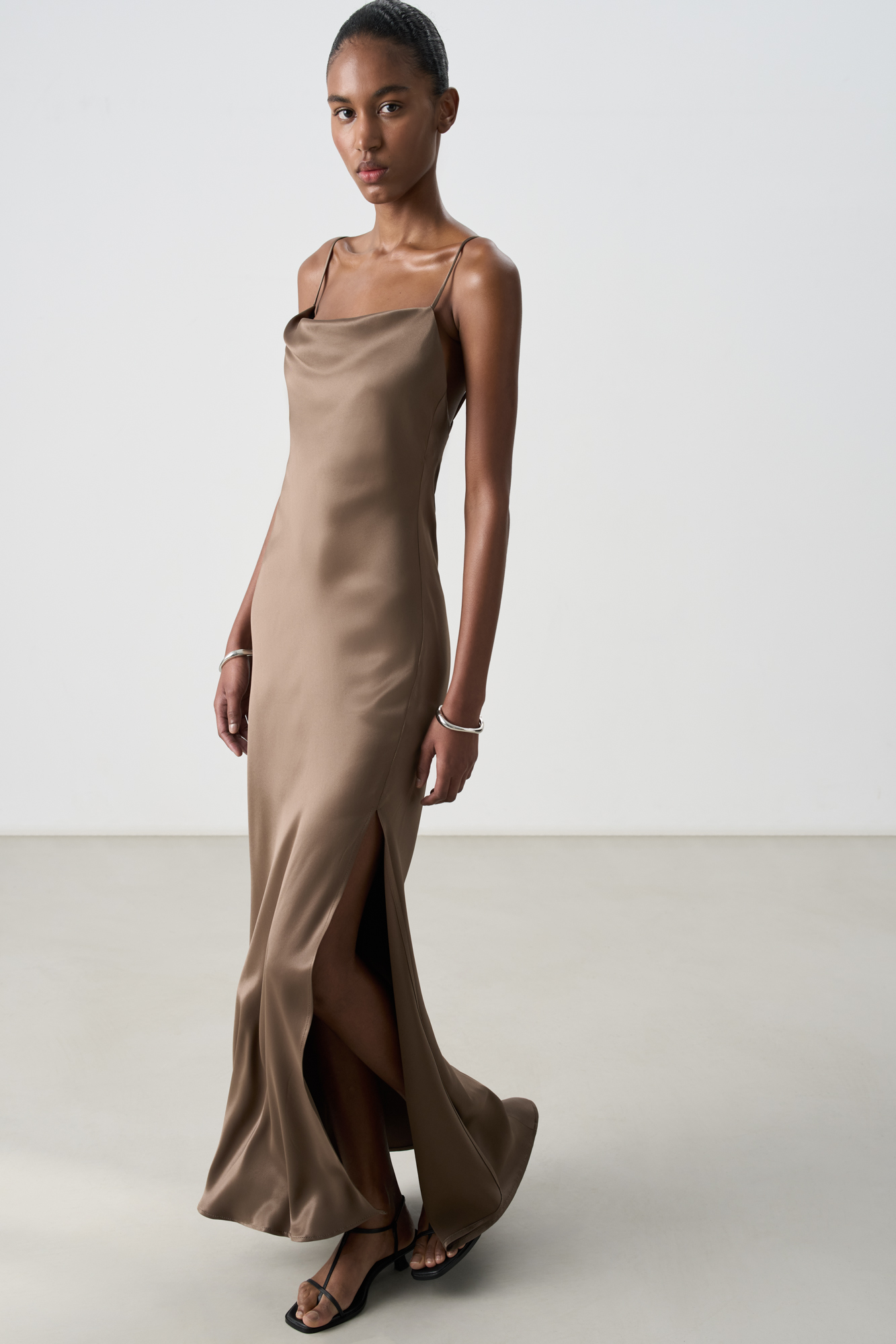 Атласное платье-комбинация длины миди из 100% вискозы. Модель приталенного силуэта, с высоким разрезом сбоку и открытой спиной,&nbsp;&nbsp;Изделие выполнено на тонких регулируемых бретелях. 