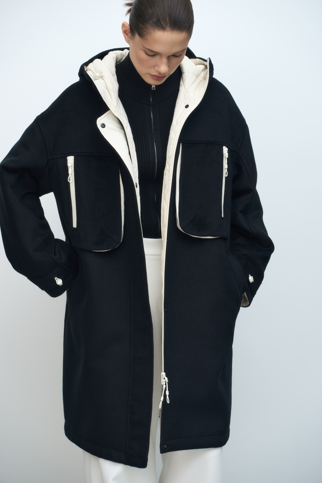 Свободное пальто из шерсти. Модель с капюшоном, накладными карманами на груди и манжетами с фиксаторами. На стеганой подкладке.