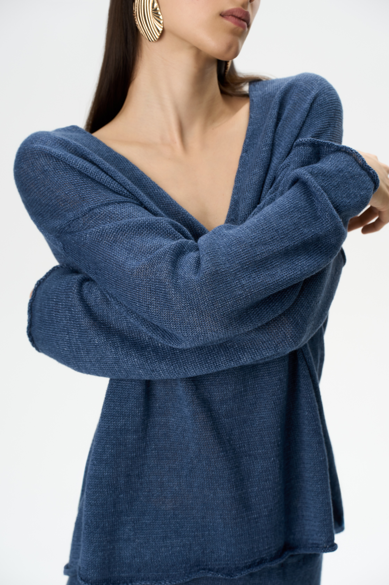 Трикотажный джемпер из 100% льна. Модель свободного силуэта с длинным рукавом и с V-образным вырезом горловины. Изделие декорировано брендированным ярлыком сбоку и валиками по низу.