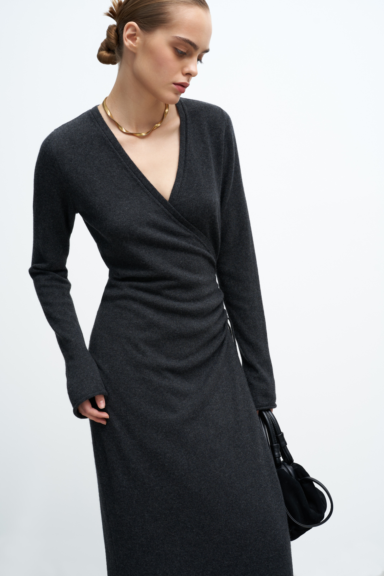 Трикотажное платье на запах из шерсти и кашемира. Модель приталенного силуэта с V-образным вырезом, длинными рукавами и кулиской на талии. Подол платья и манжеты рукавов декорированы валиками.