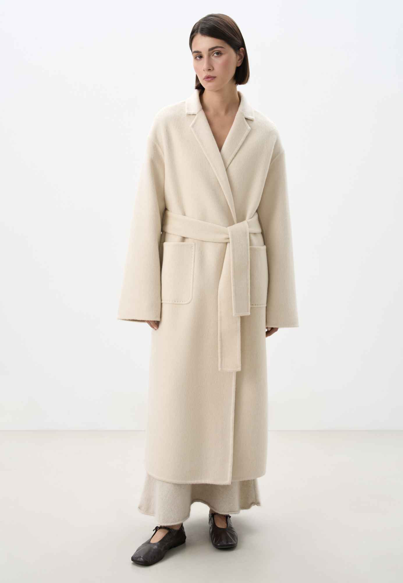 Классическое длинное пальто из шерсти и кашемира. Модель прямого кроя, с узкими лацканами, глубокими накладными карманами и высокими разрезами по бокам. Пояс в комплекте.<br />
При пошиве этого изделия была использована технология double face - на изделиях, сшитых по этой технологии, внутренняя сторона выглядит также аккуратно, как и внешняя.<br />
